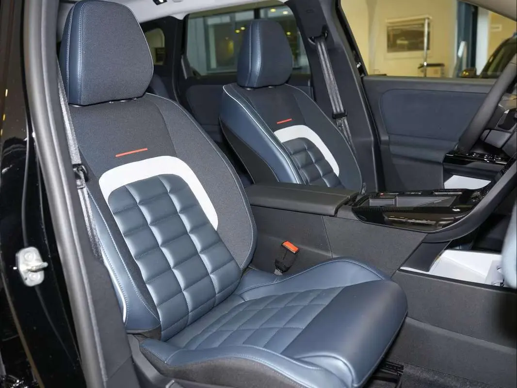 Vue intérieure côté avant gauche du Citroën C5 Aircross New Hybrid 2026, sièges bi-matière bleu et noir avec surpiqûres.