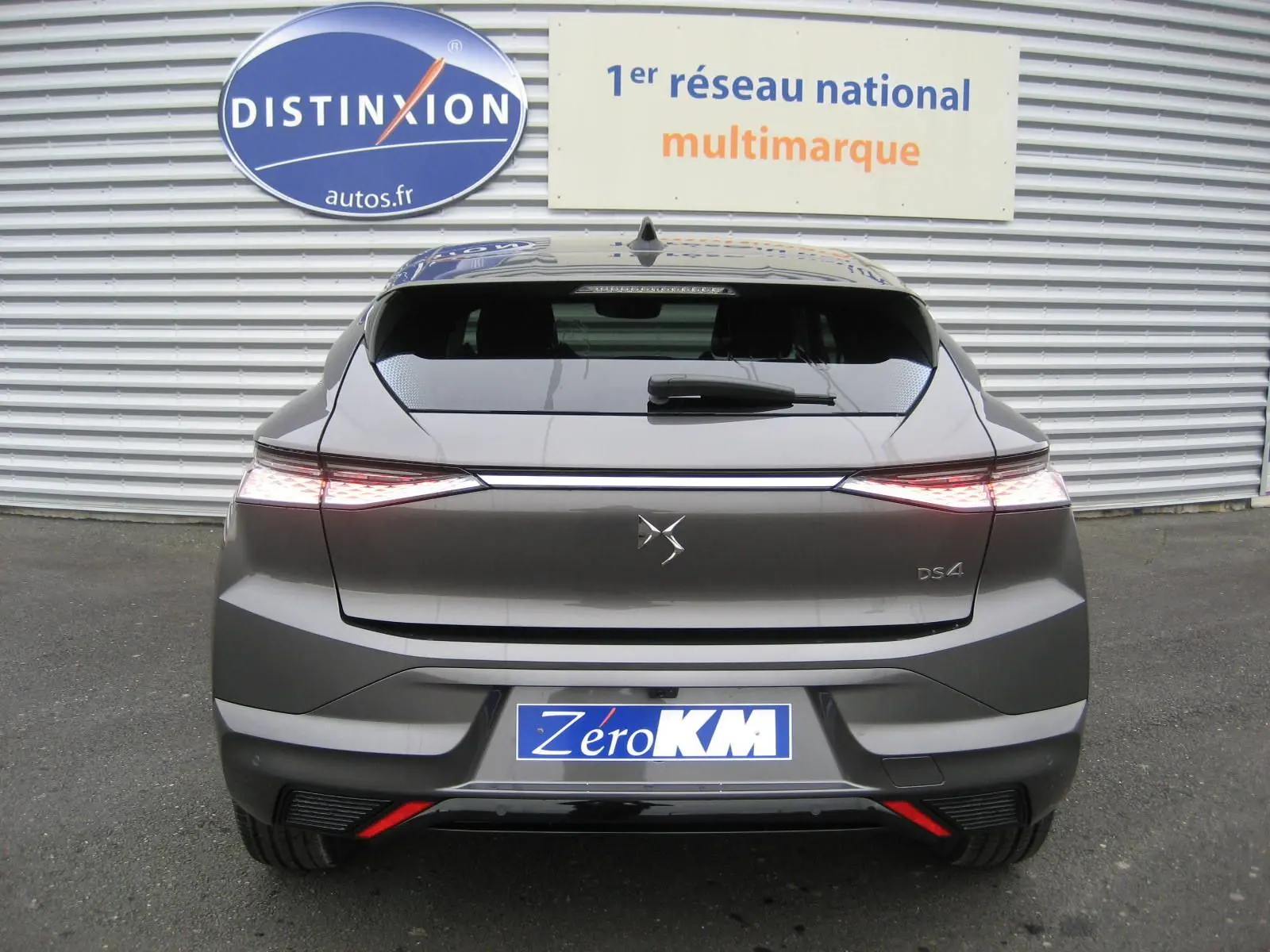 Vue arrière d'une DS4 gris platinium 2024 avec feux LED étirés et logo DS centré sur le hayon.