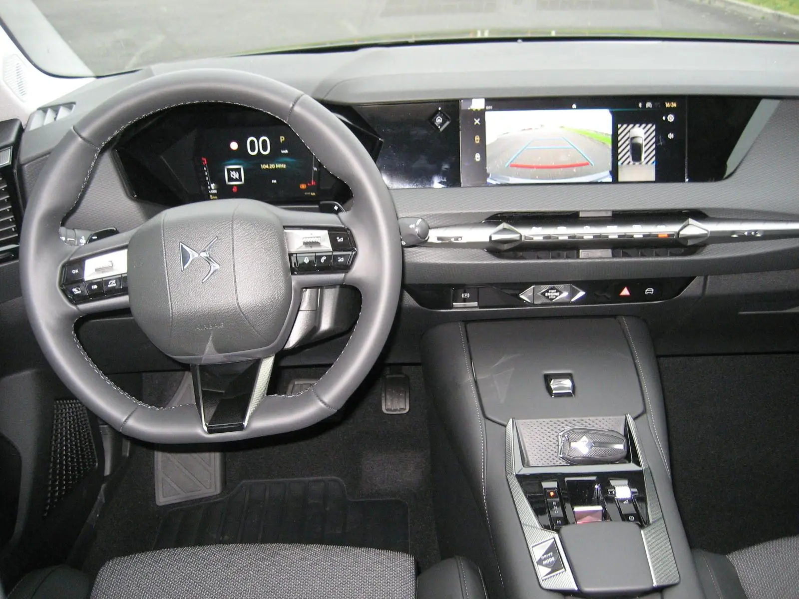 Vue intérieure du tableau de bord et volant du DS4 2024 avec écran central affichant la caméra de recul.