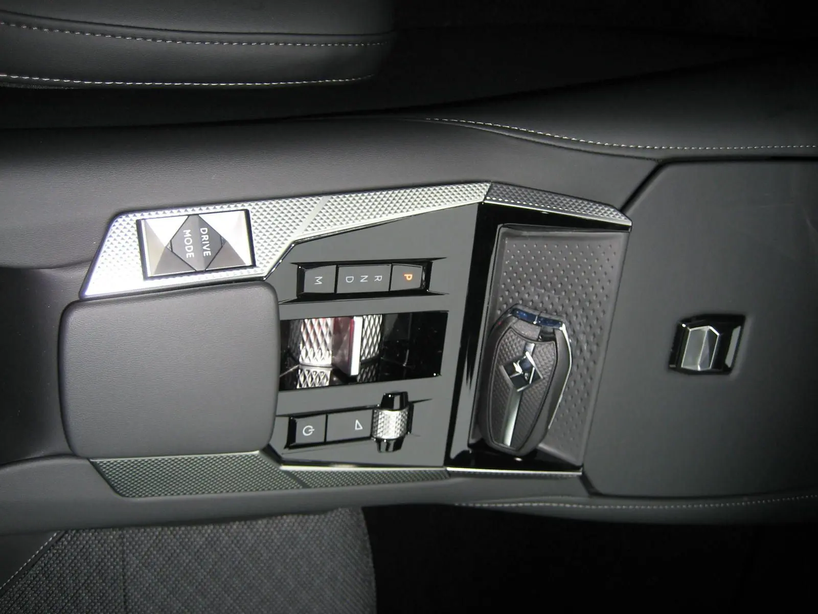 Gros plan sur la console centrale noire du DS4 2024 avec sélecteur de vitesse tactile et clé de contact élégante.