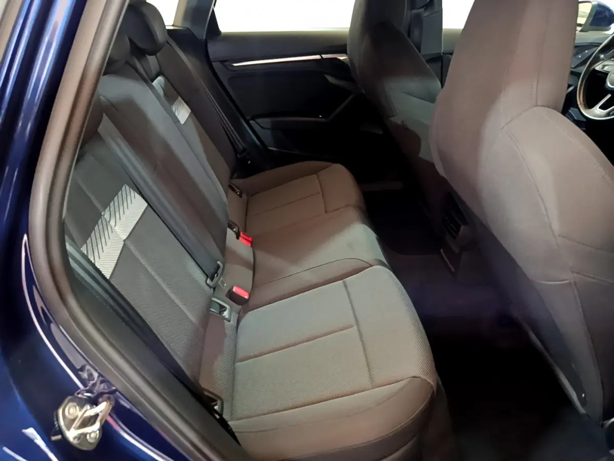 Vue intérieure côté gauche montrant la banquette arrière grise de l'Audi A3 35 TFSI 150 MHEV Business Line bleu 2023.