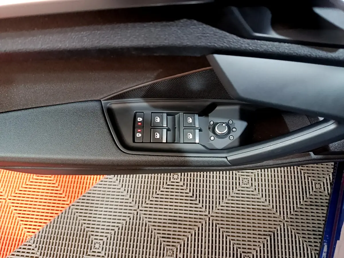 Panneau de commandes des vitres et rétroviseurs côté gauche intérieur d'une Audi A3 bleu 2023.