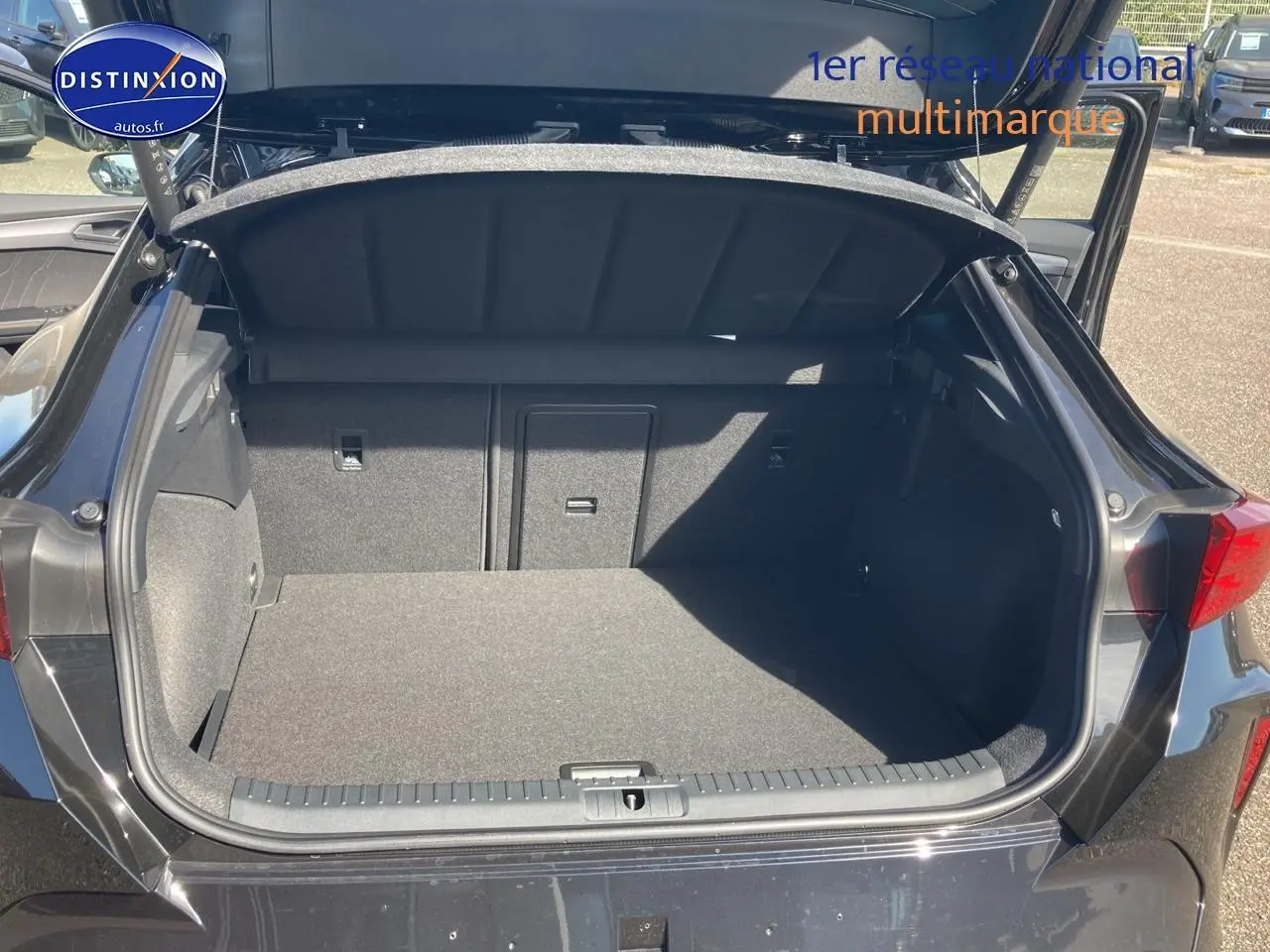 Coffre ouvert vu de l'arrière d'une CUPRA Formentor noir midnight, montrant l'espace de chargement vide.