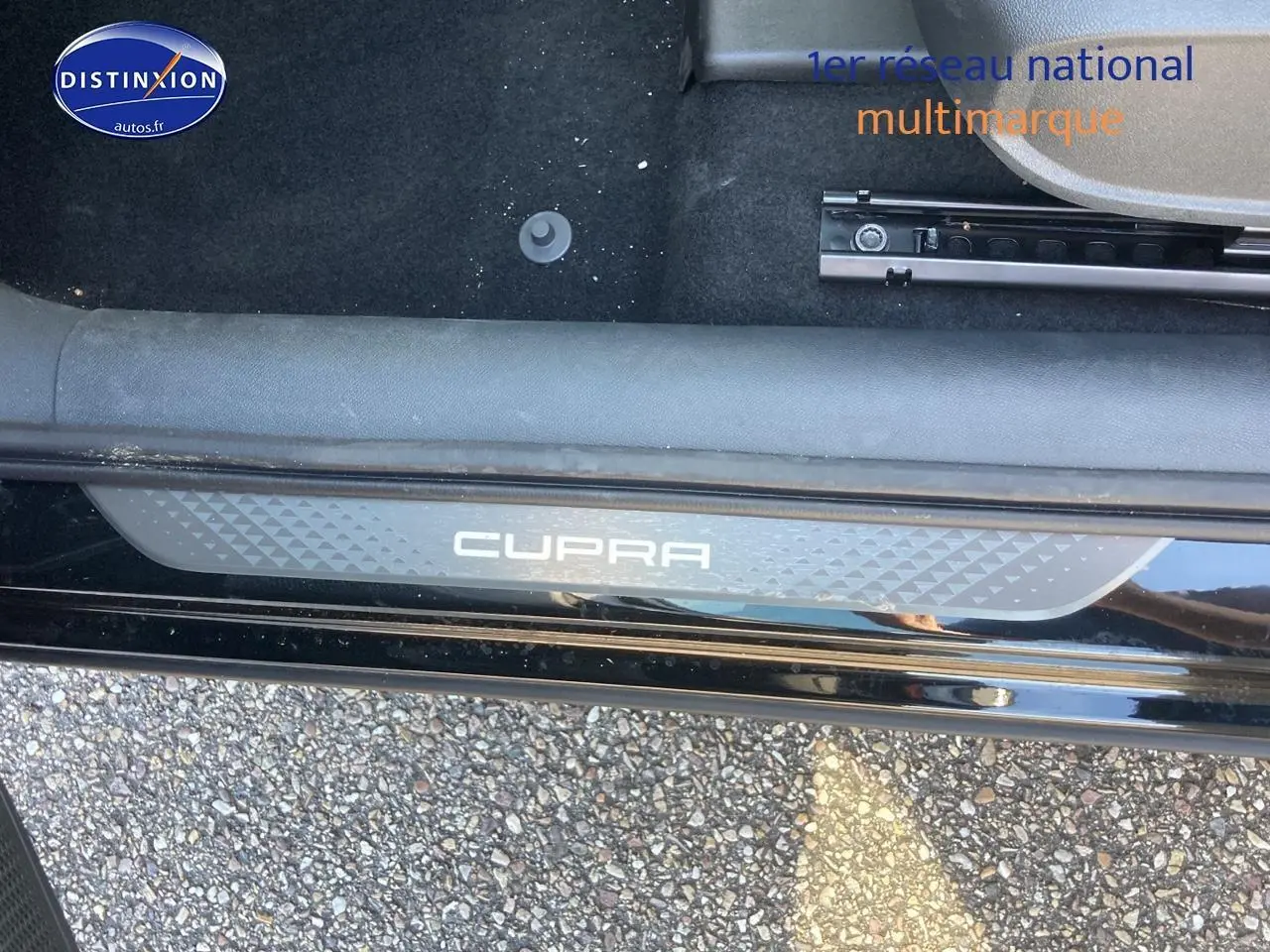 Vue rapprochée de la marche d’entrée noire midnight avec logo CUPRA éclairé sur sol gravillonné.