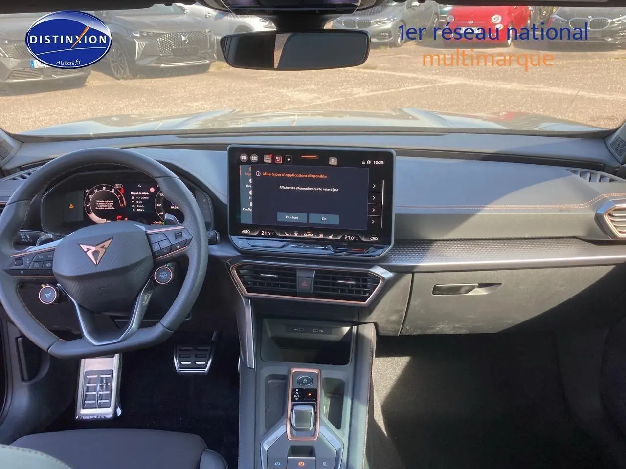 Vue intérieure avant du tableau de bord et volant cuir noir du CUPRA Formentor 1.5 etsi hybrid avec écran tactile central allumé.