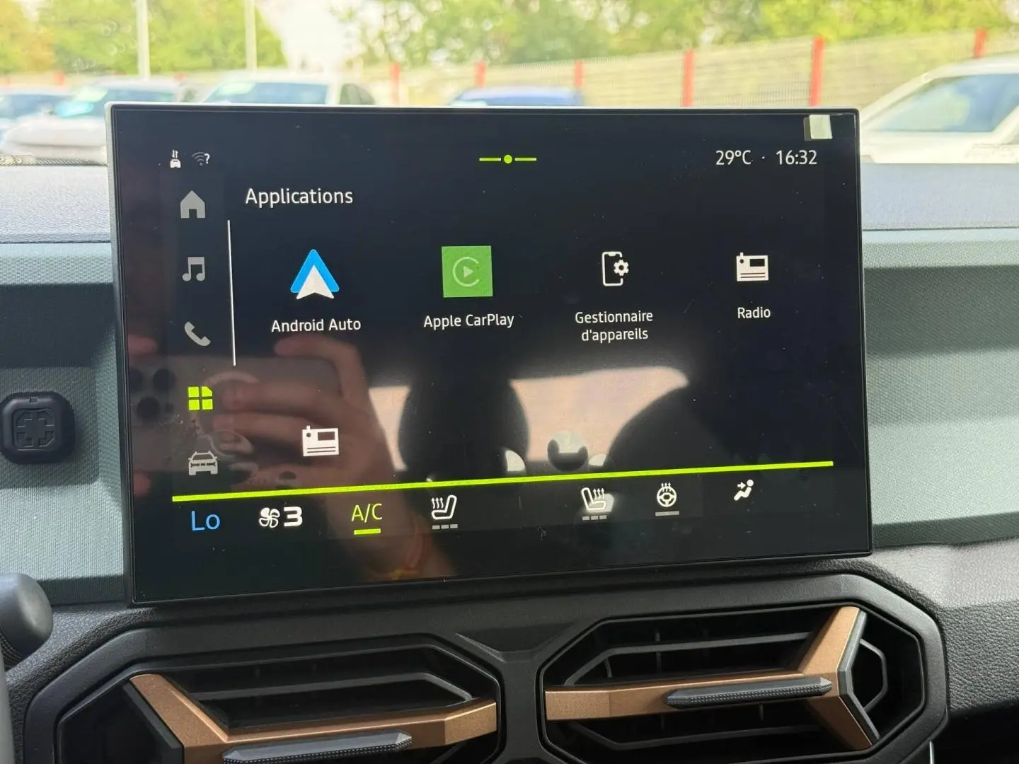 Écran tactile central du tableau de bord du Dacia Duster gris, affichant les applications Android Auto et Apple CarPlay.