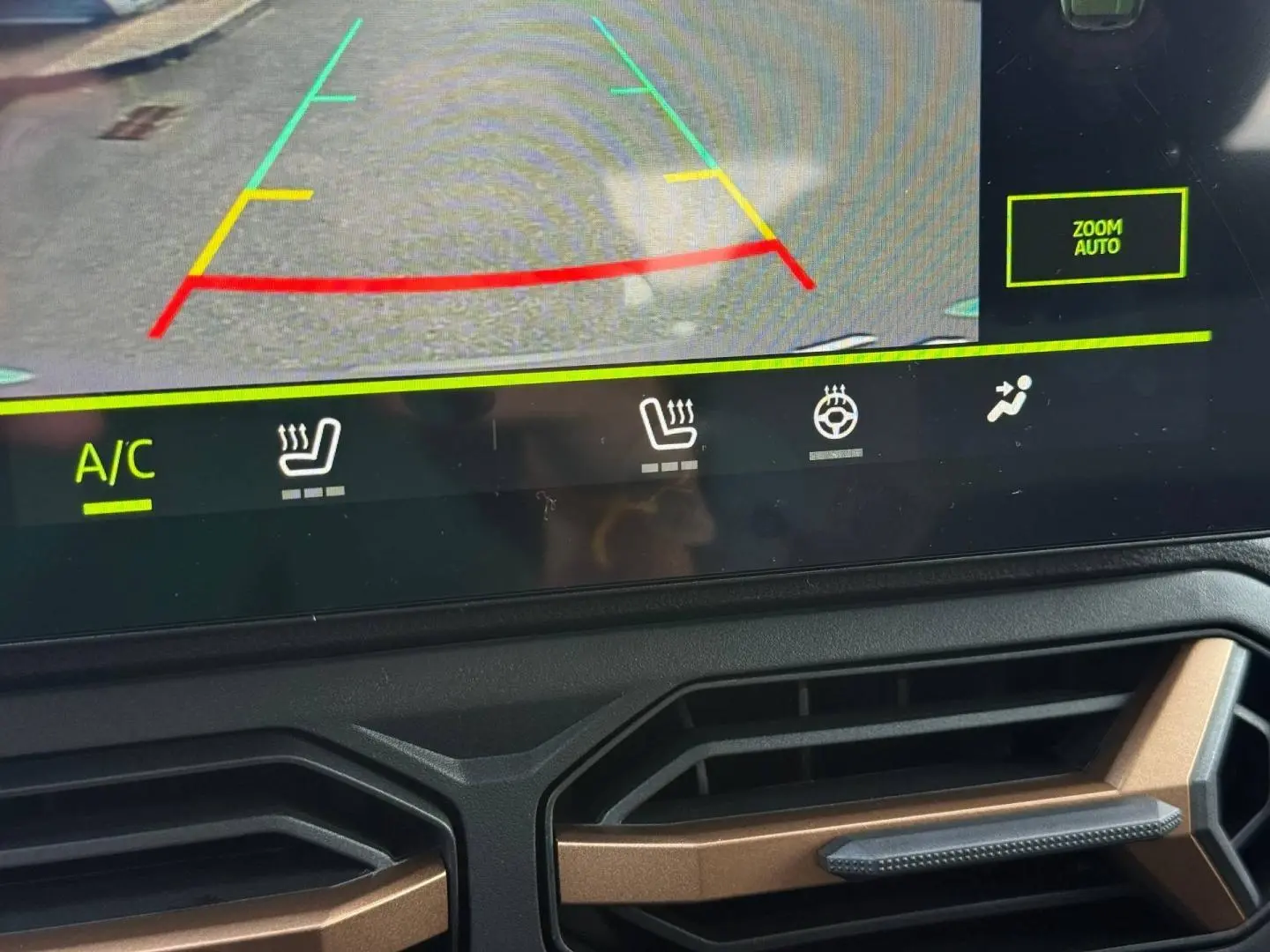 Détail de l’écran tactile avec caméra de recul et aérateurs noirs et bronze du tableau de bord du Dacia Duster gris.