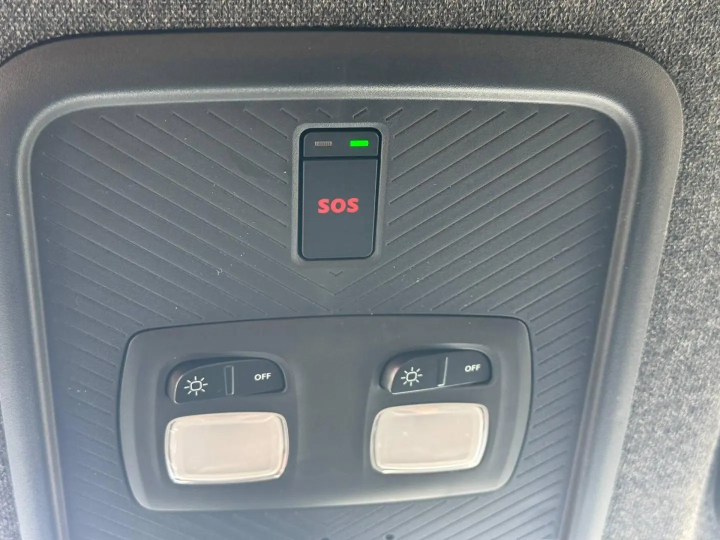 Vue en gros plan du plafonnier intérieur noir avec bouton SOS rouge et commandes d'éclairage du Dacia Duster 2026.