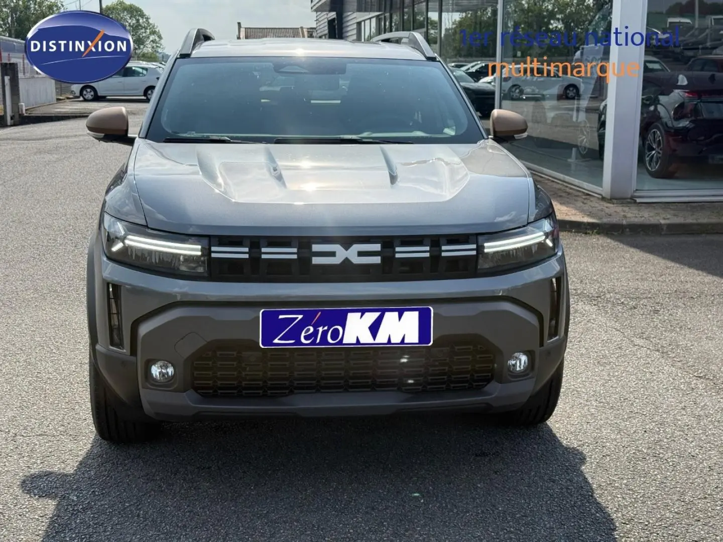 Vue avant d'un Dacia Duster gris 2026 avec calandre noire et feux LED horizontaux allumés.