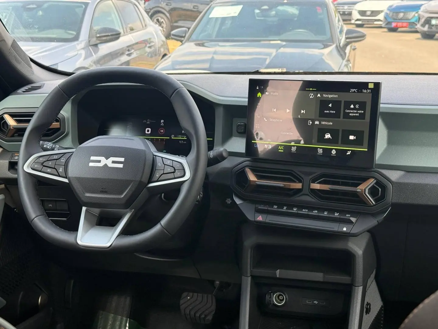 Vue intérieure du tableau de bord du Dacia Duster 2026 avec écran tactile et volant multifonction noir.
