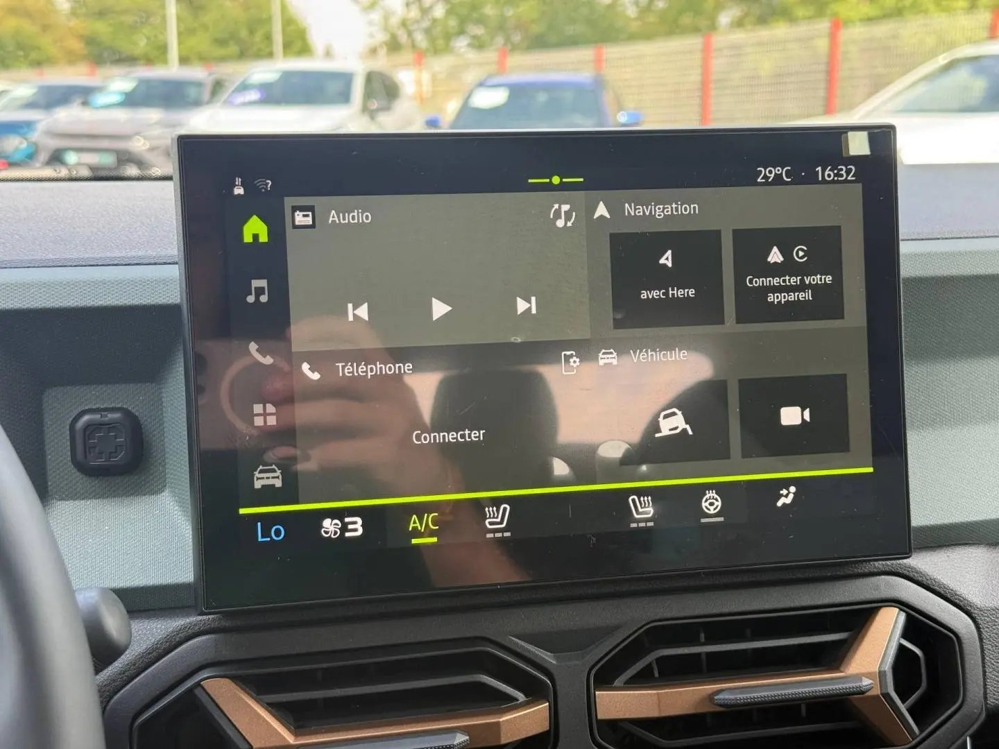 Écran tactile central du tableau de bord du Dacia Duster gris 2026, affichant les options audio et navigation.