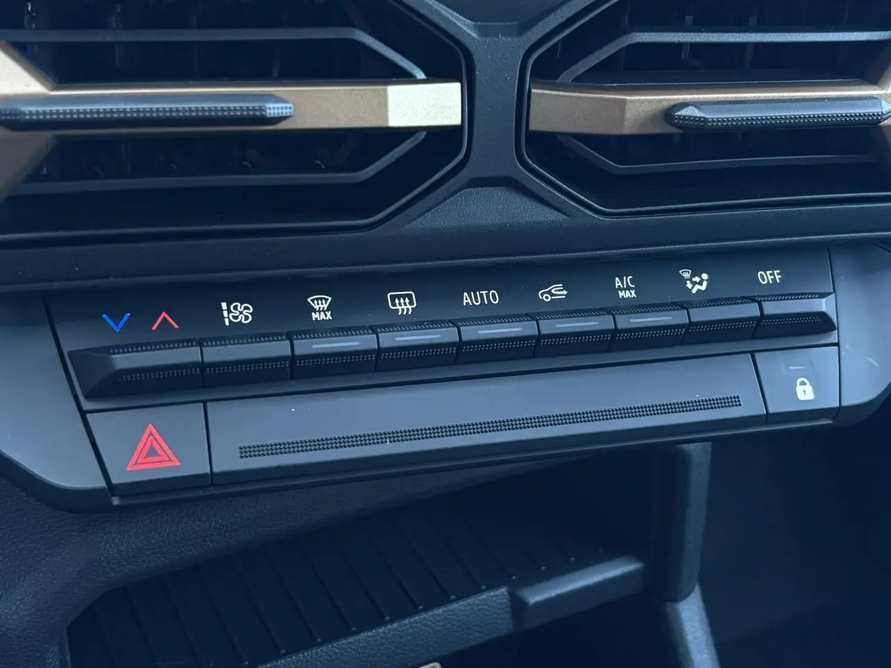 Détail des commandes de climatisation et sécurité du tableau de bord noir du Dacia Duster Blanc Glacier 2026.