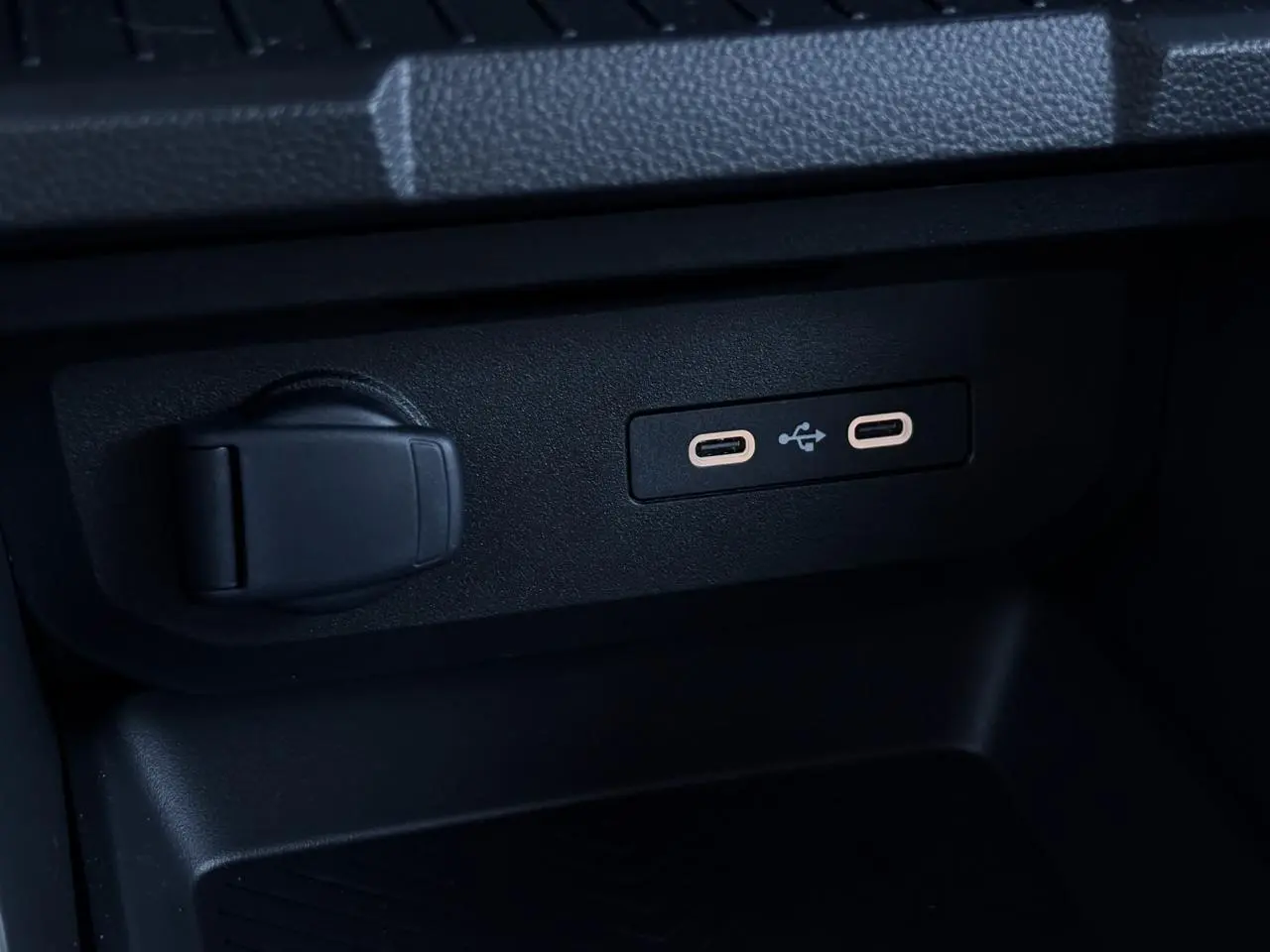 Gros plan sur deux prises USB type C et une prise 12V noires dans la console centrale du Dacia Duster Blanc Glacier.