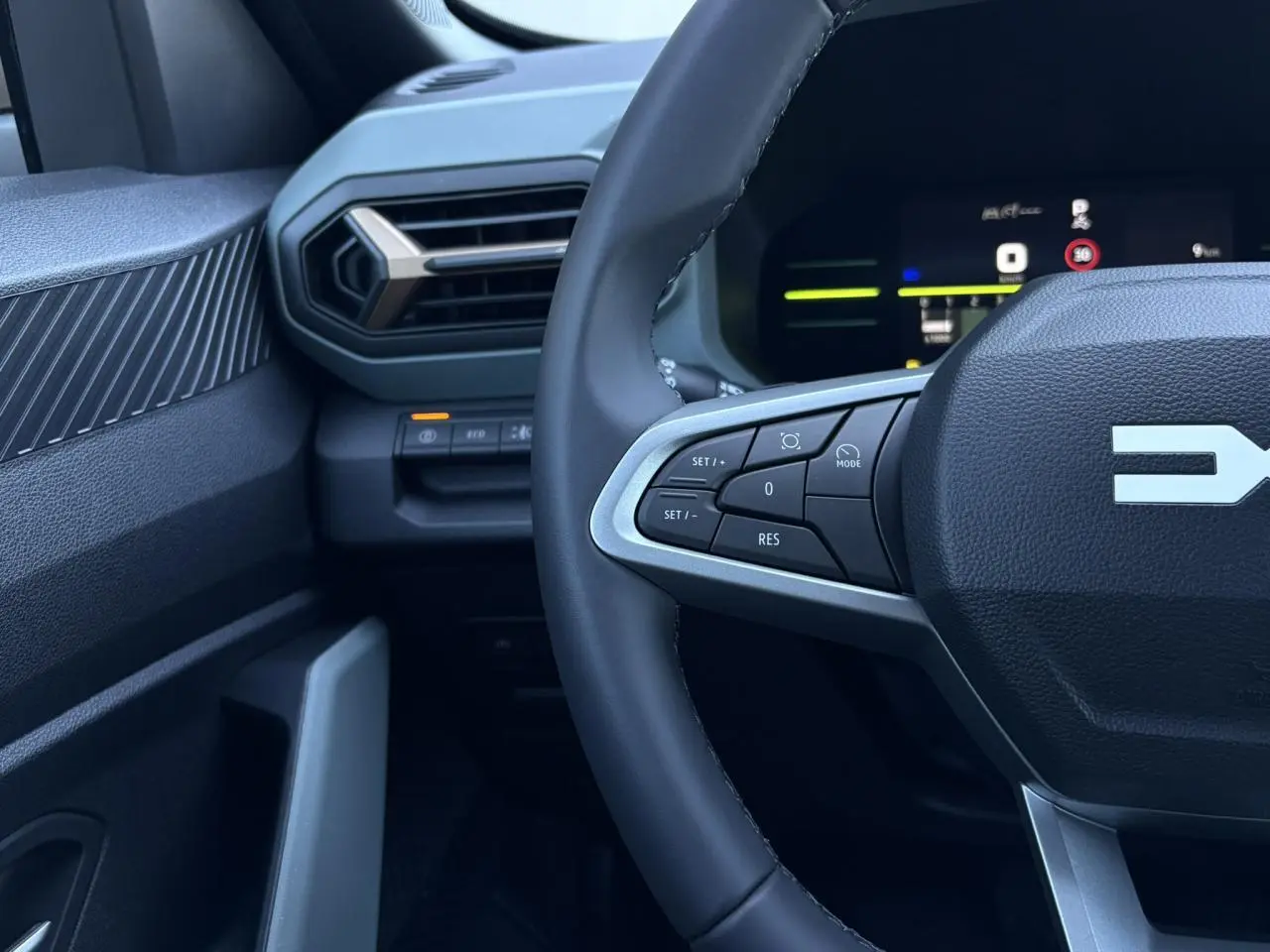 Gros plan sur le volant côté gauche et la partie gauche du tableau de bord du Dacia Duster 2026, intérieur noir.