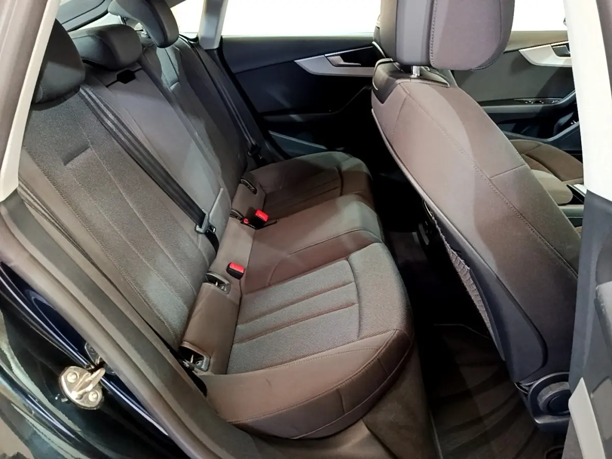 Vue intérieure côté arrière gauche montrant la banquette arrière en tissu gris de l'Audi A5 noir 2021.