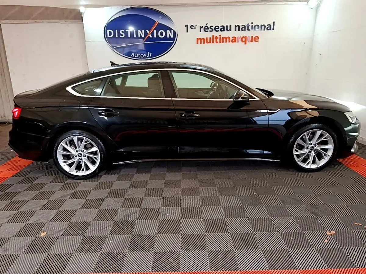 Profil côté gauche d'une Audi A5 noire 2021, élégante avec jantes alliage et lignes fluides dans un showroom.