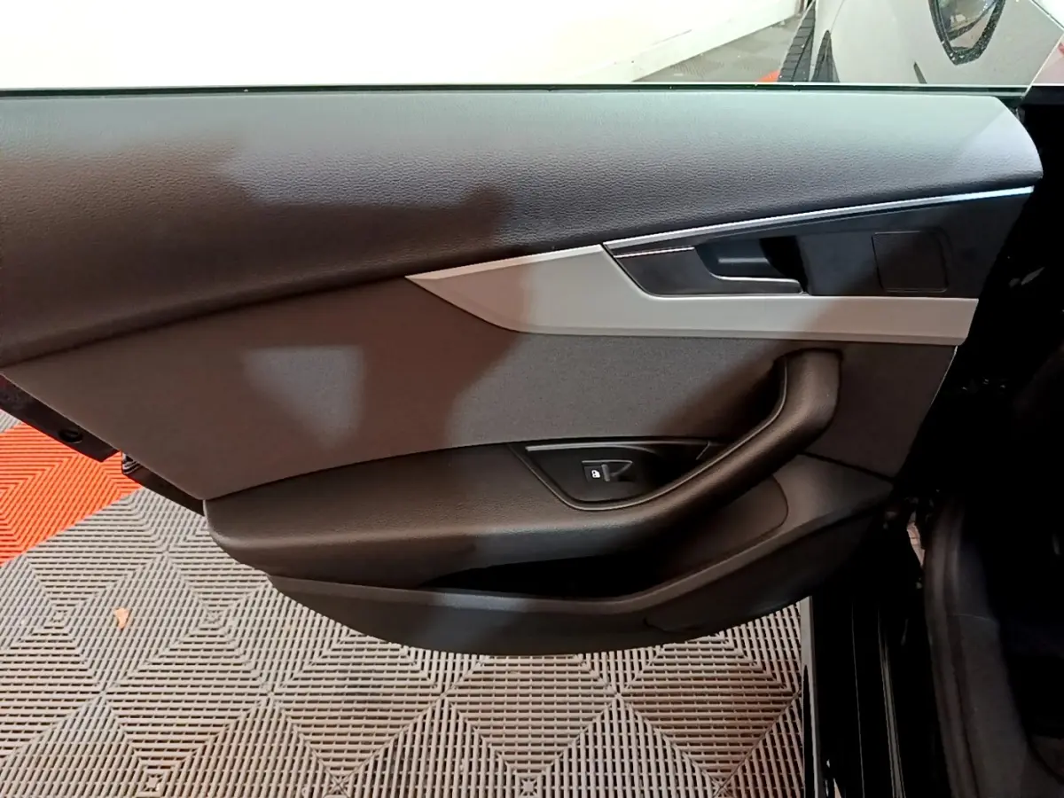 Porte intérieure côté gauche noire de l'Audi A5 35 TFSI 2021 avec poignée intégrée et bouton de verrouillage