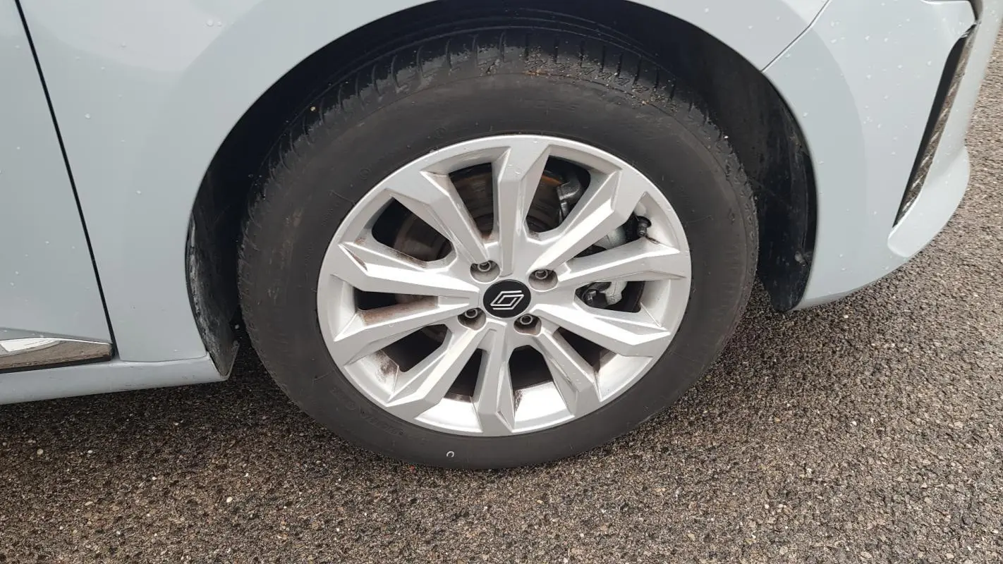 Gros plan sur la roue avant gauche gris clair d'une Renault Clio V Blue dCi 2025 avec jante alliage moderne.
