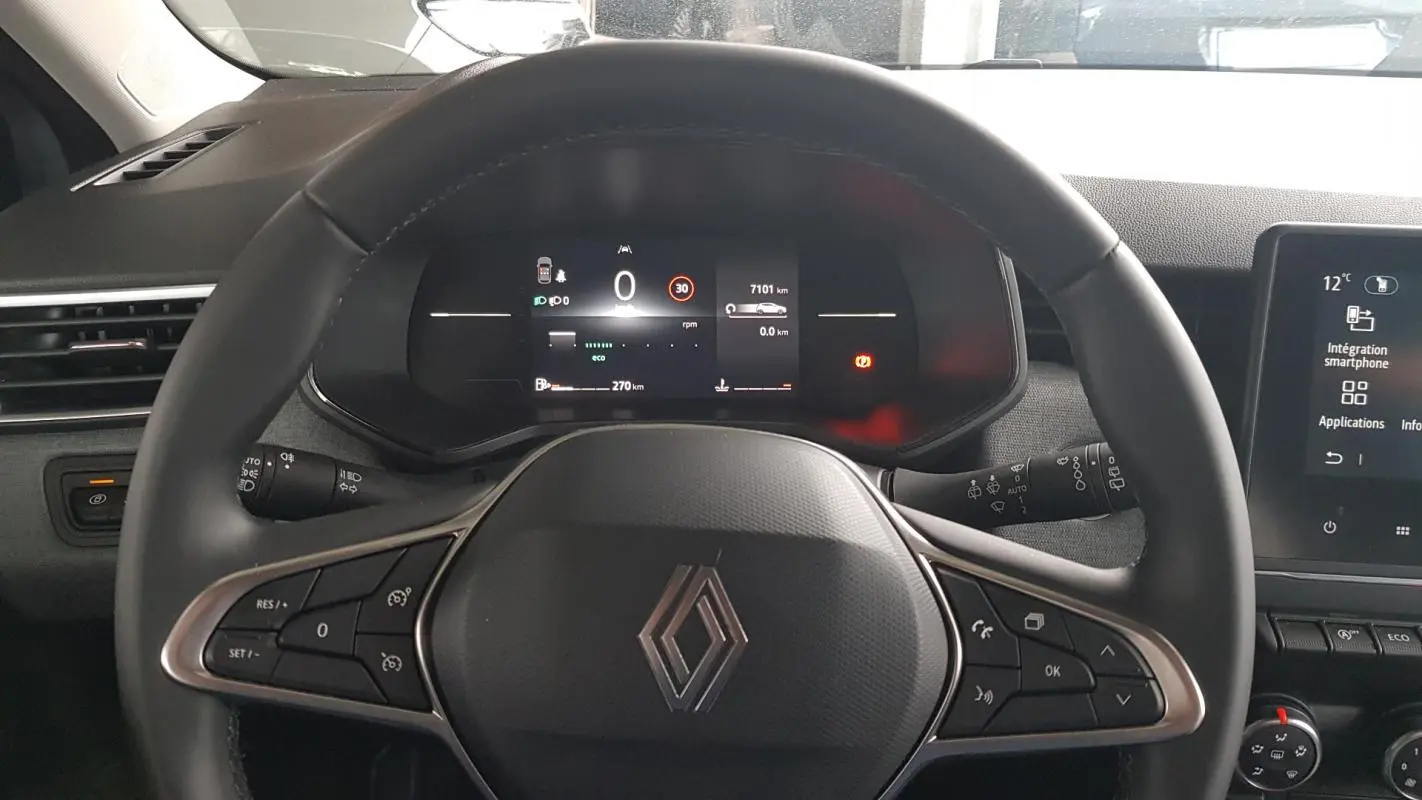 Vue intérieure centrée sur le volant noir de la Renault Clio V Blue dCi 2025 avec tableau de bord digital et écran tactile.