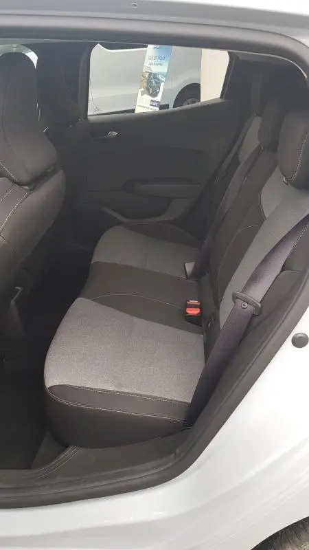 Vue intérieure côté droit des sièges arrière gris clair et foncé de la Renault Clio V Blue dCi 2025 avec ceinture de sécurité visible.