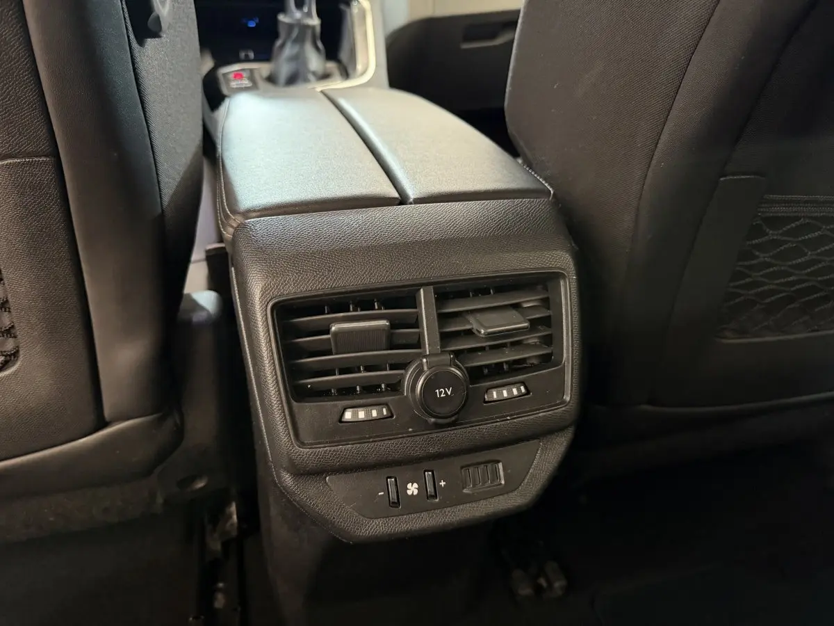 Vue rapprochée des aérateurs arrière et prise 12V noirs entre les sièges noirs du Peugeot 5008 bleu 2019.
