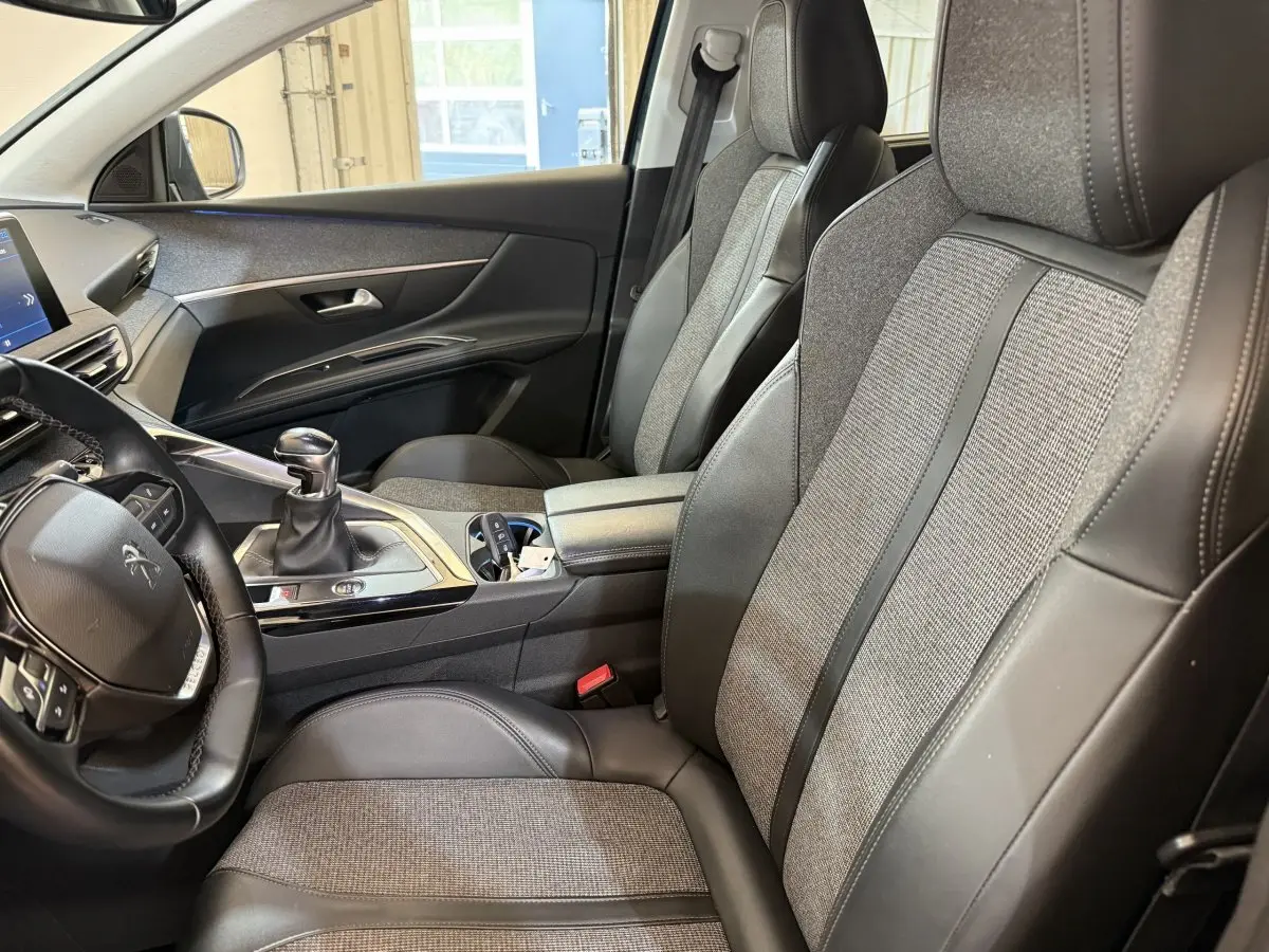 Vue intérieure côté conducteur du Peugeot 5008 Puretech 130 S&S Allure 2019, sièges cuir et tissu gris, volant multifonctions.