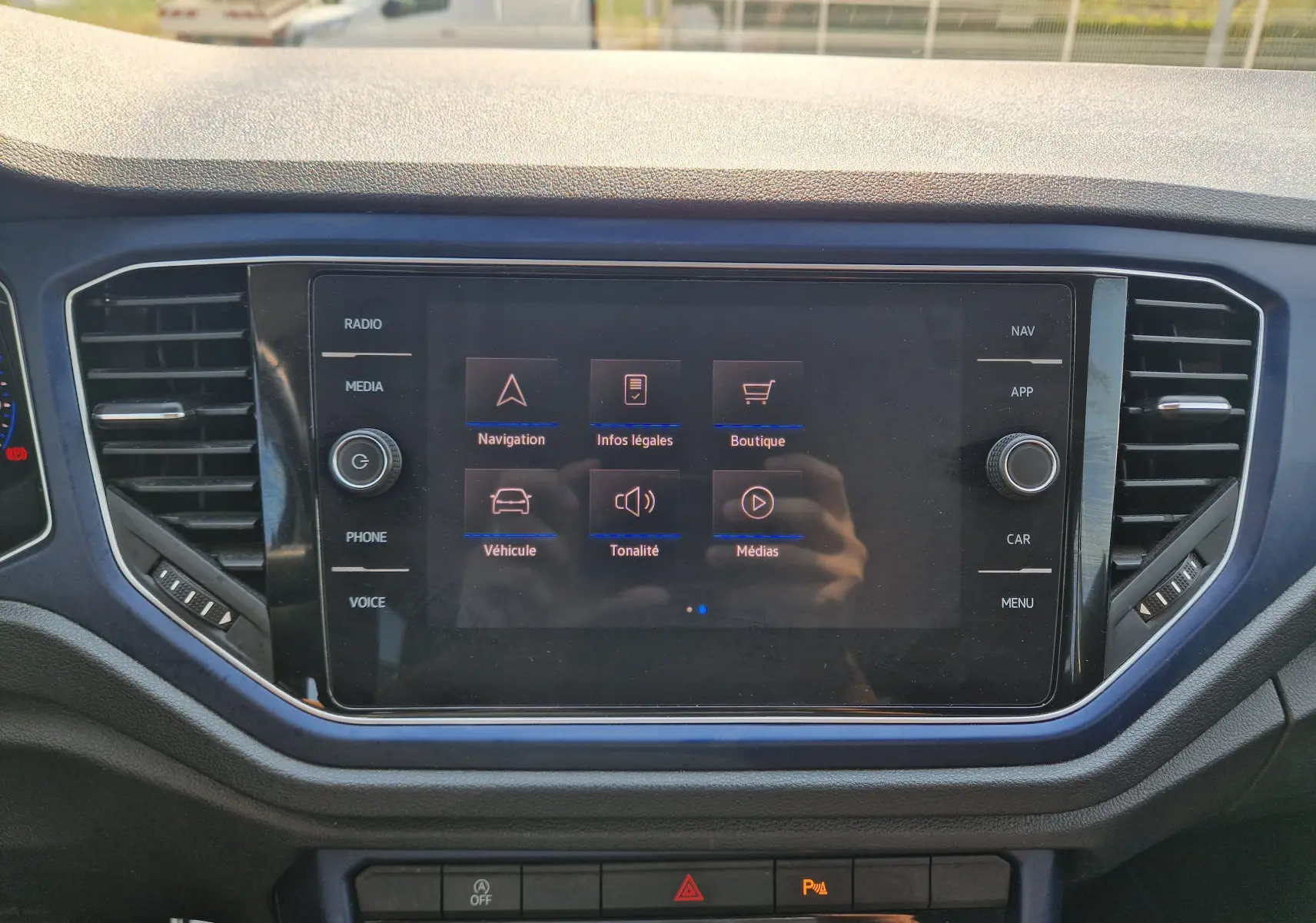 Vue rapprochée de l'écran tactile central du Volkswagen T-Roc gris foncé 2021, affichant le menu principal multimédia.