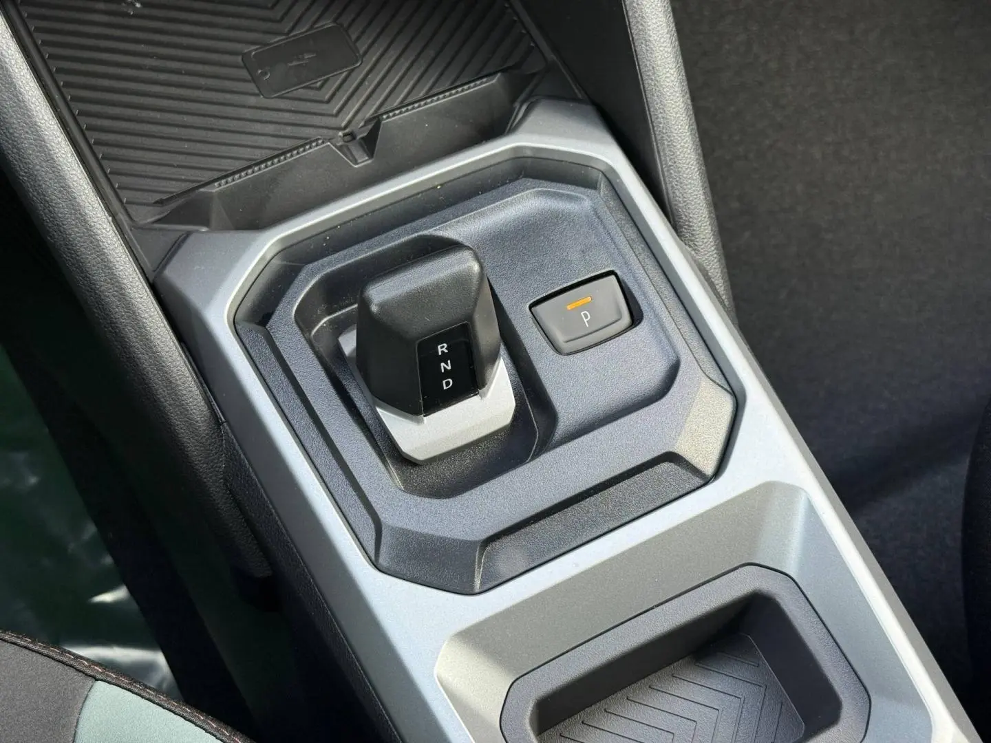 Gros plan sur la commande de boîte automatique et bouton de parking du Dacia Duster 2026, intérieur gris et noir.
