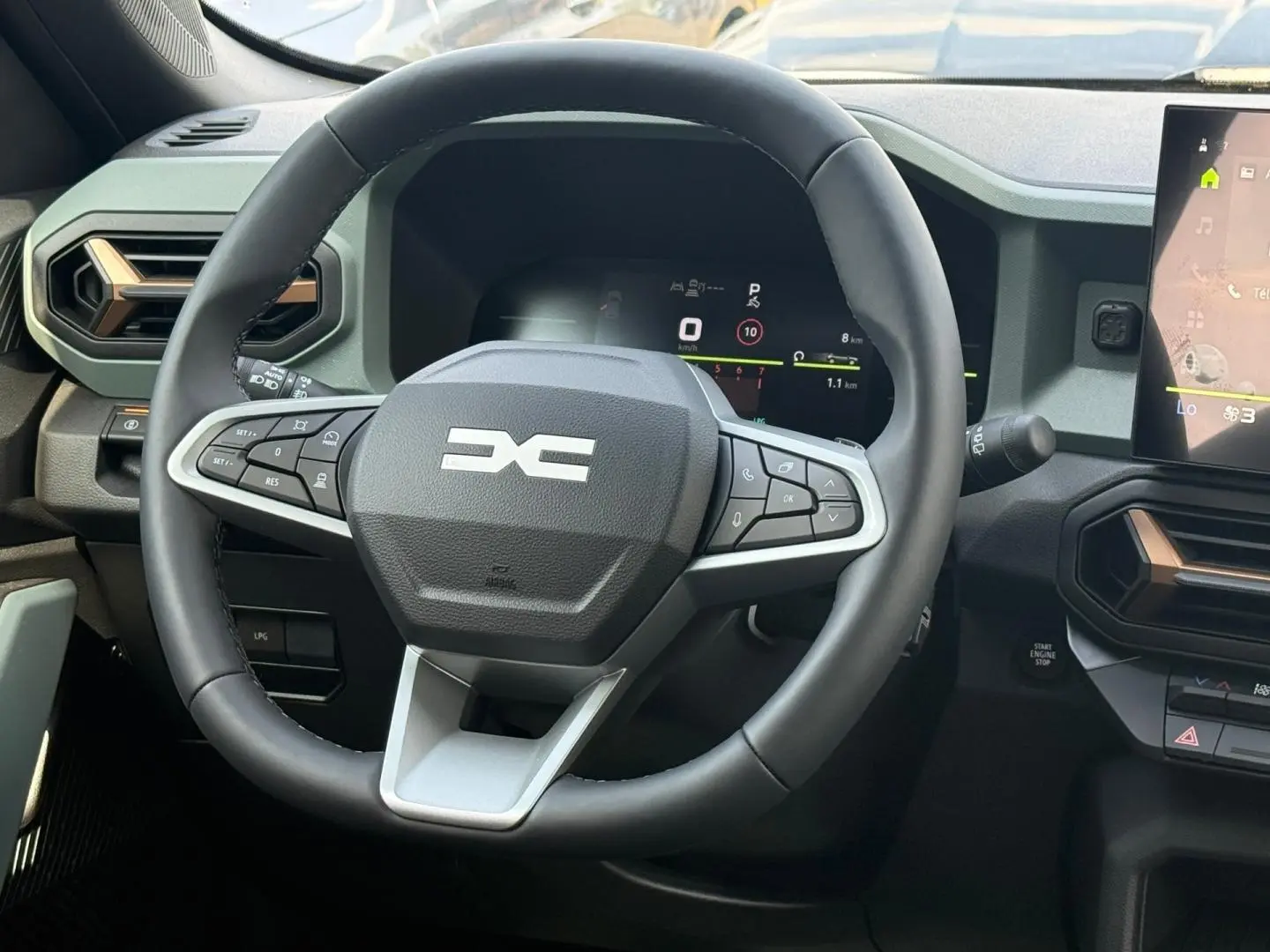 Vue rapprochée du volant noir multifonction du Dacia Duster 2026 avec tableau de bord numérique et écran tactile.