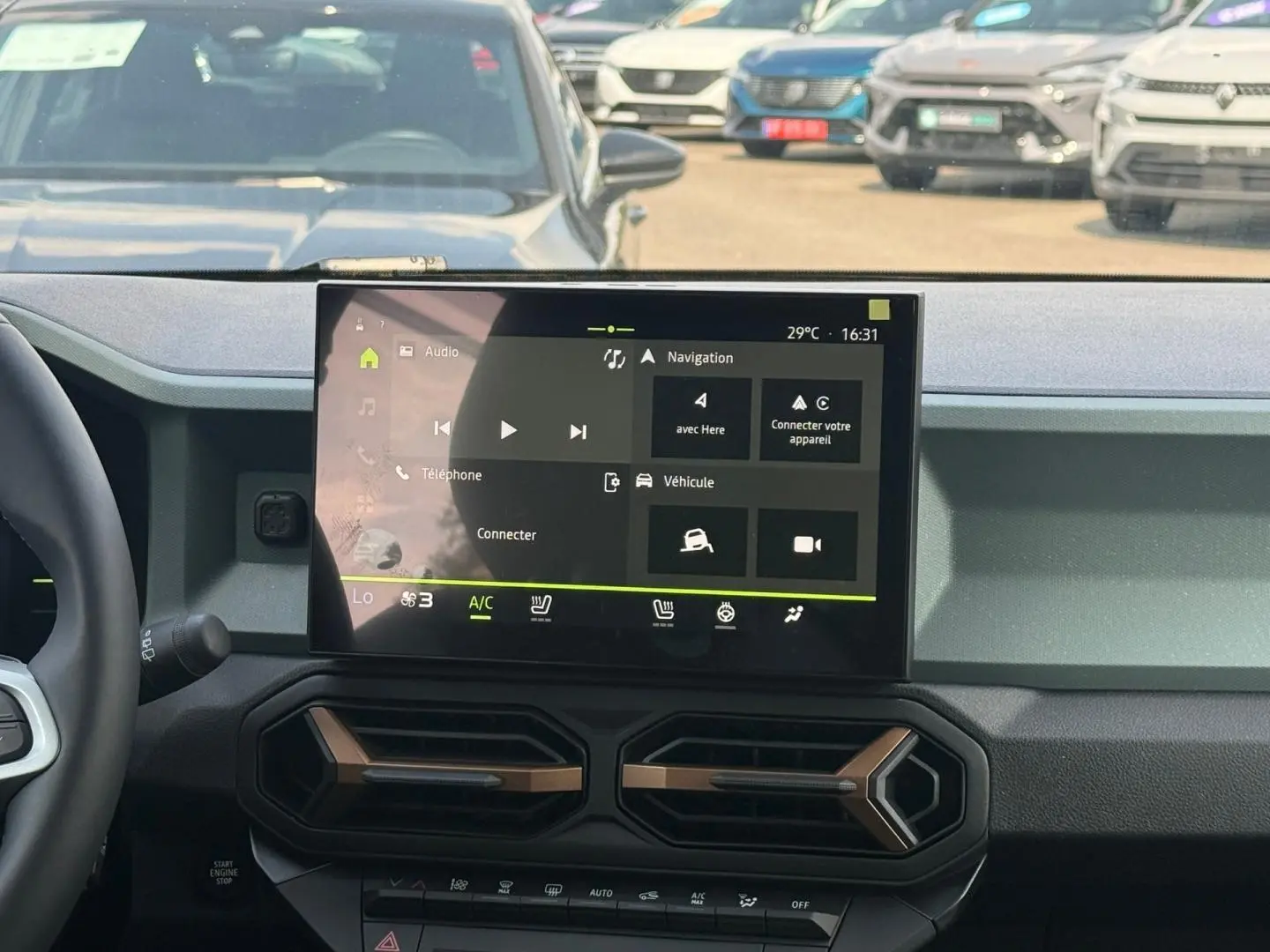Vue intérieure du tableau de bord du Dacia Duster blanc 2026, avec écran tactile central et aérateurs hexagonaux.