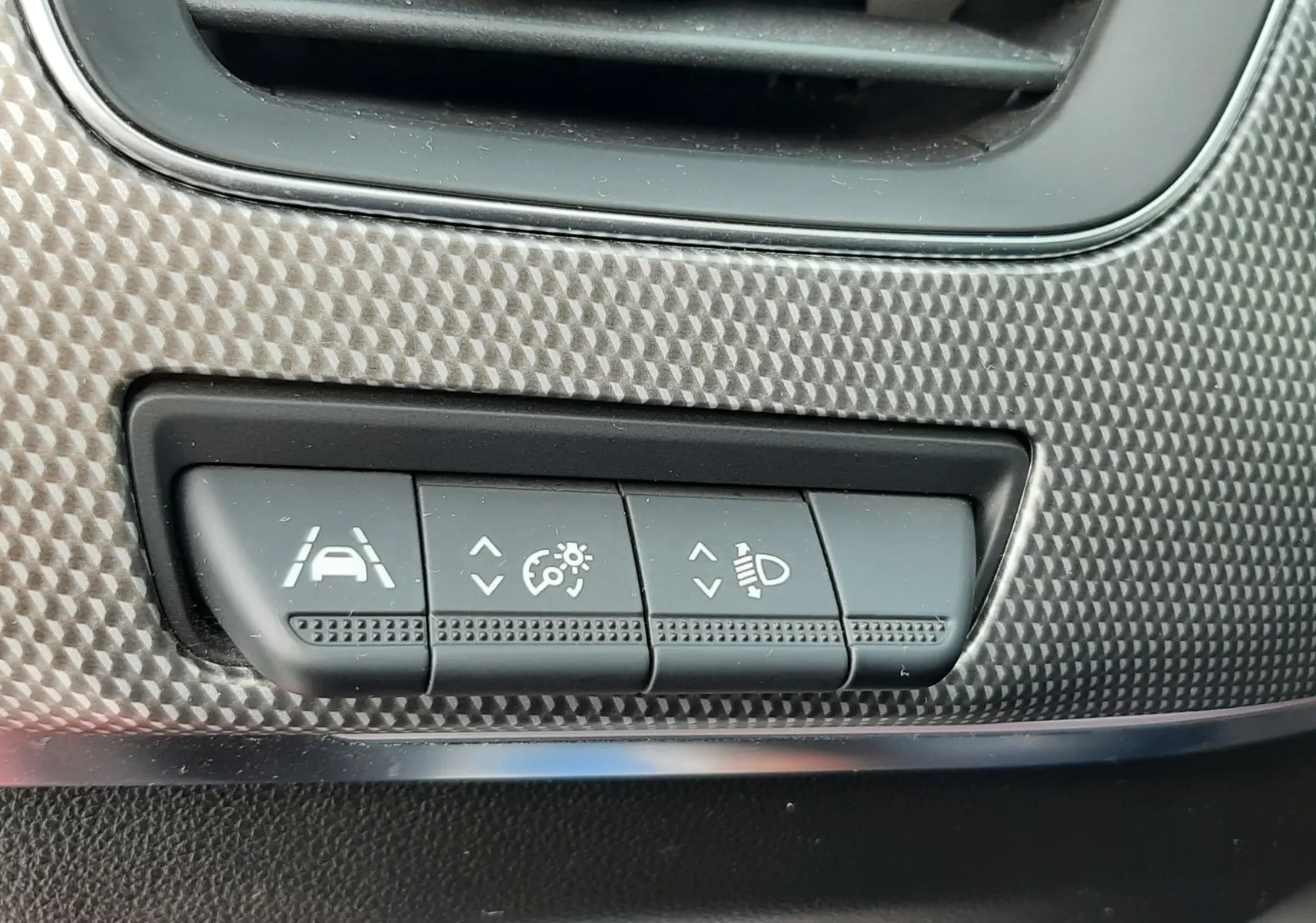 Gros plan sur les commandes de réglage d'assistance et d'éclairage du tableau de bord du Renault Arkana 2021.