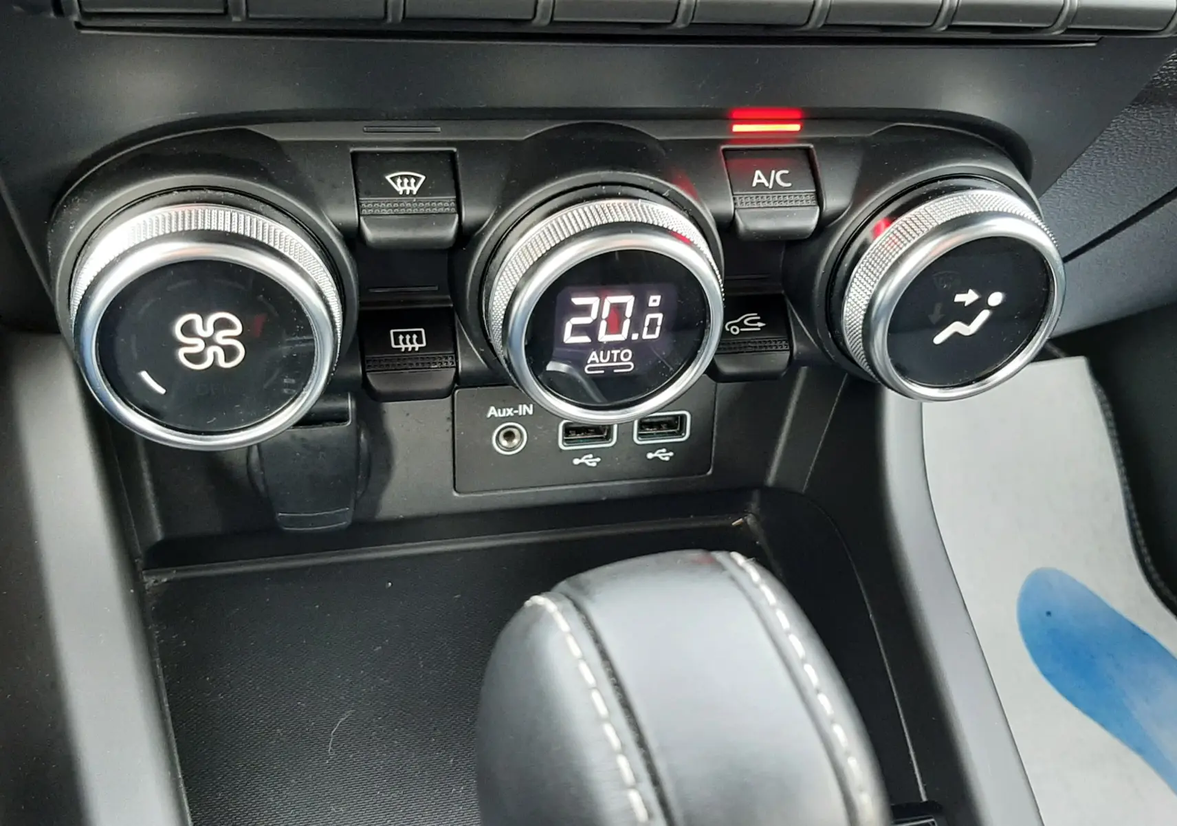 Gros plan sur les commandes de climatisation et la console centrale du Renault Arkana rouge Flame 2021, version Intens.