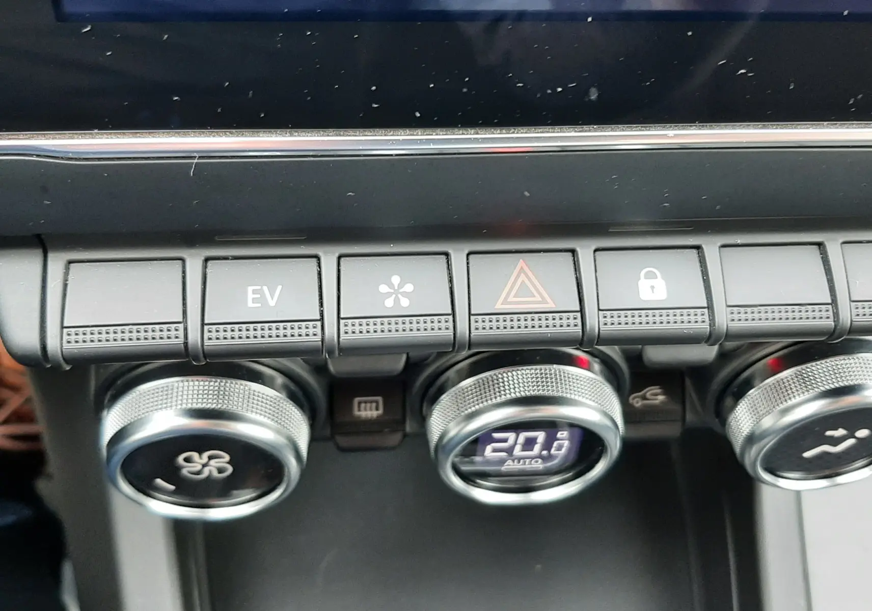 Vue rapprochée de la console centrale du Renault Arkana 1.6 E-TECH 145 Intens, boutons de climatisation et écran tactile.