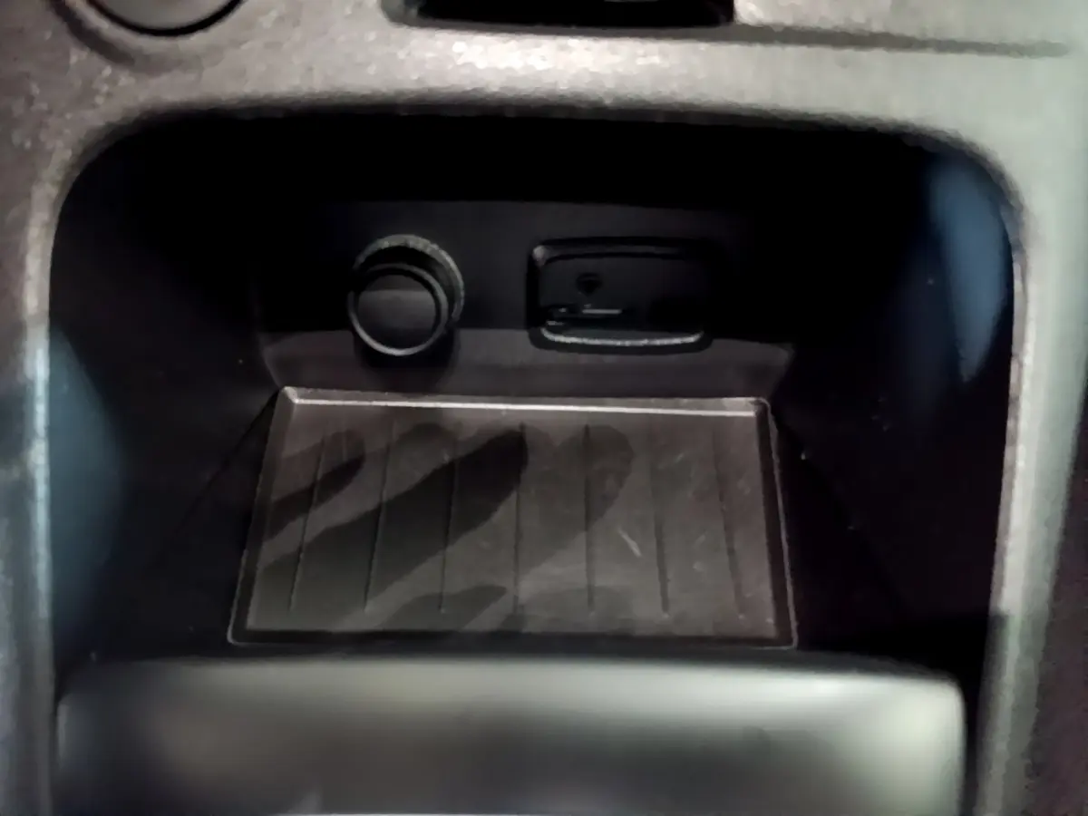 Prise 12V et port USB en gros plan dans le compartiment central du Renault Captur Intens orange 2019.