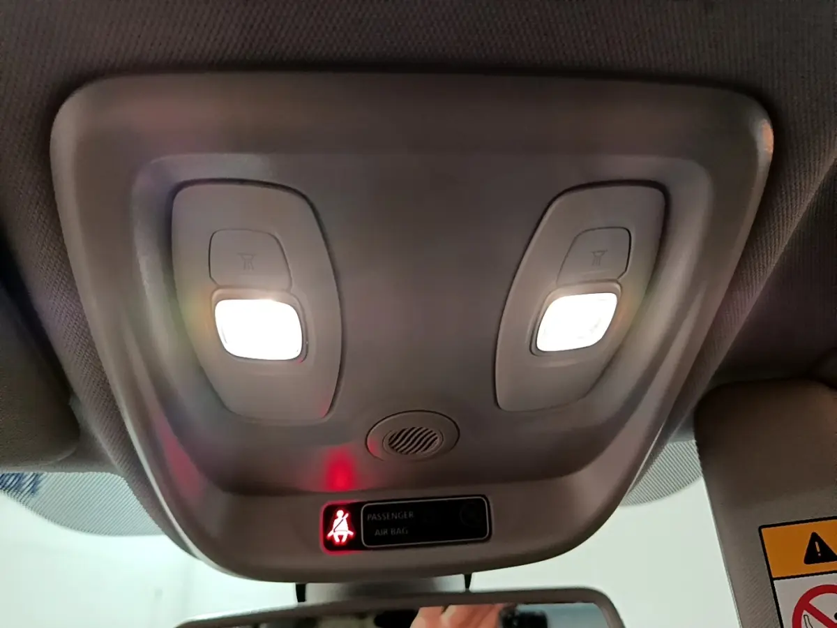 Plafonnier intérieur avec lampes allumées et témoin d'airbag passager dans un Renault Captur orange 2019.