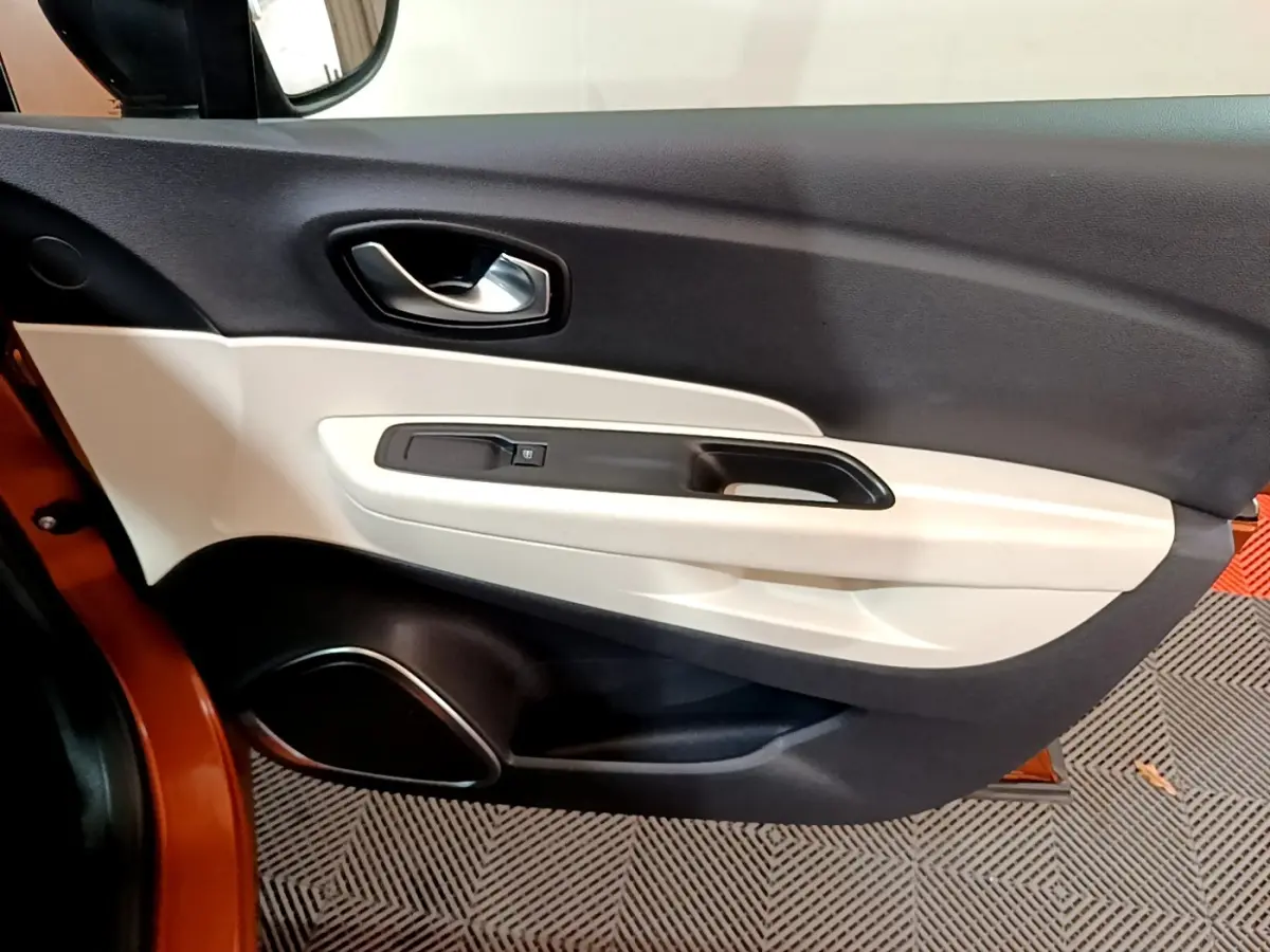 Vue rapprochée de la porte côté gauche du Renault Captur orange 2019, avec garniture bicolore noire et beige.
