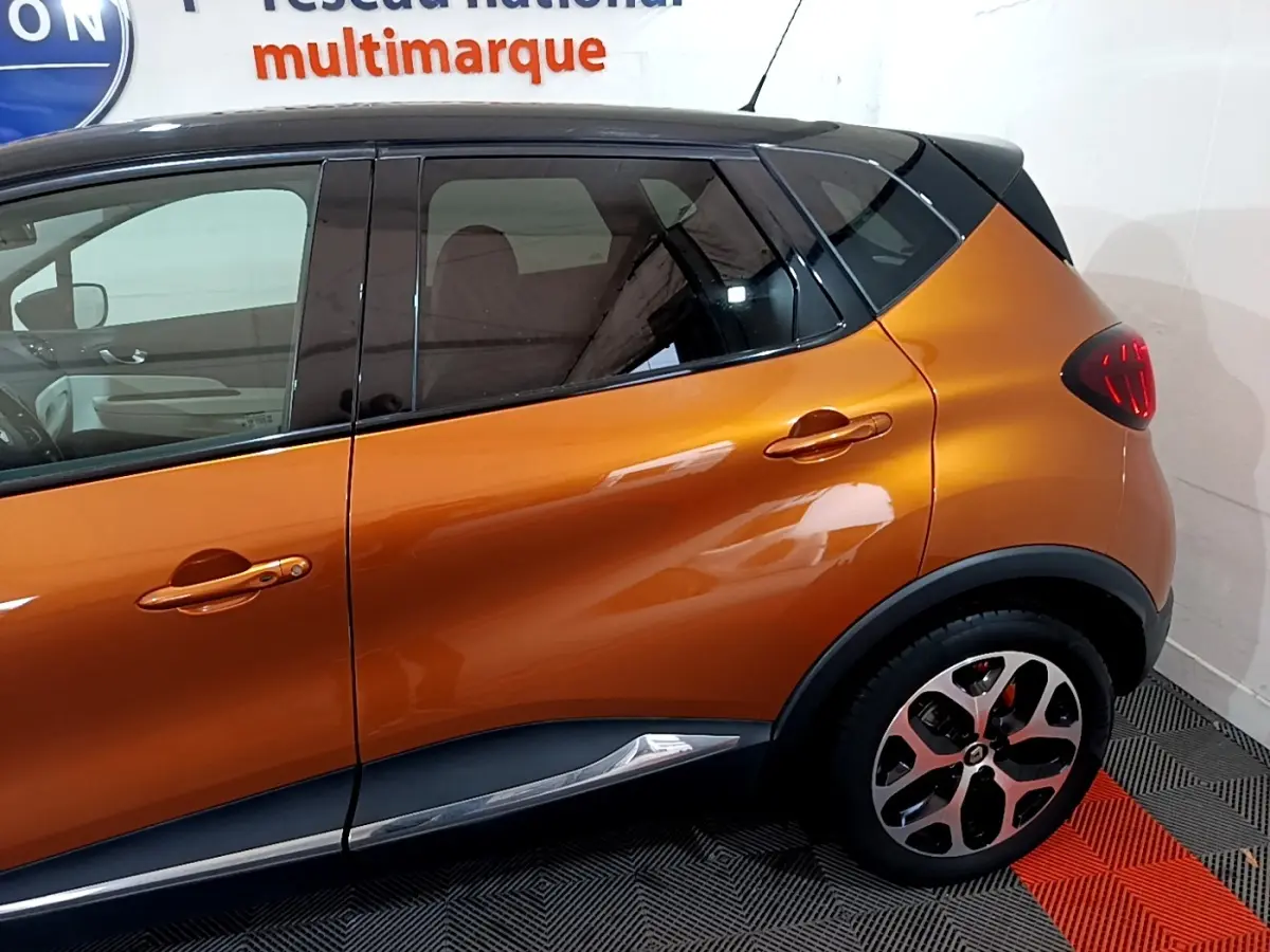 Profil côté droit du Renault Captur Intens orange 2019 avec toit noir et jantes alliage distinctives.