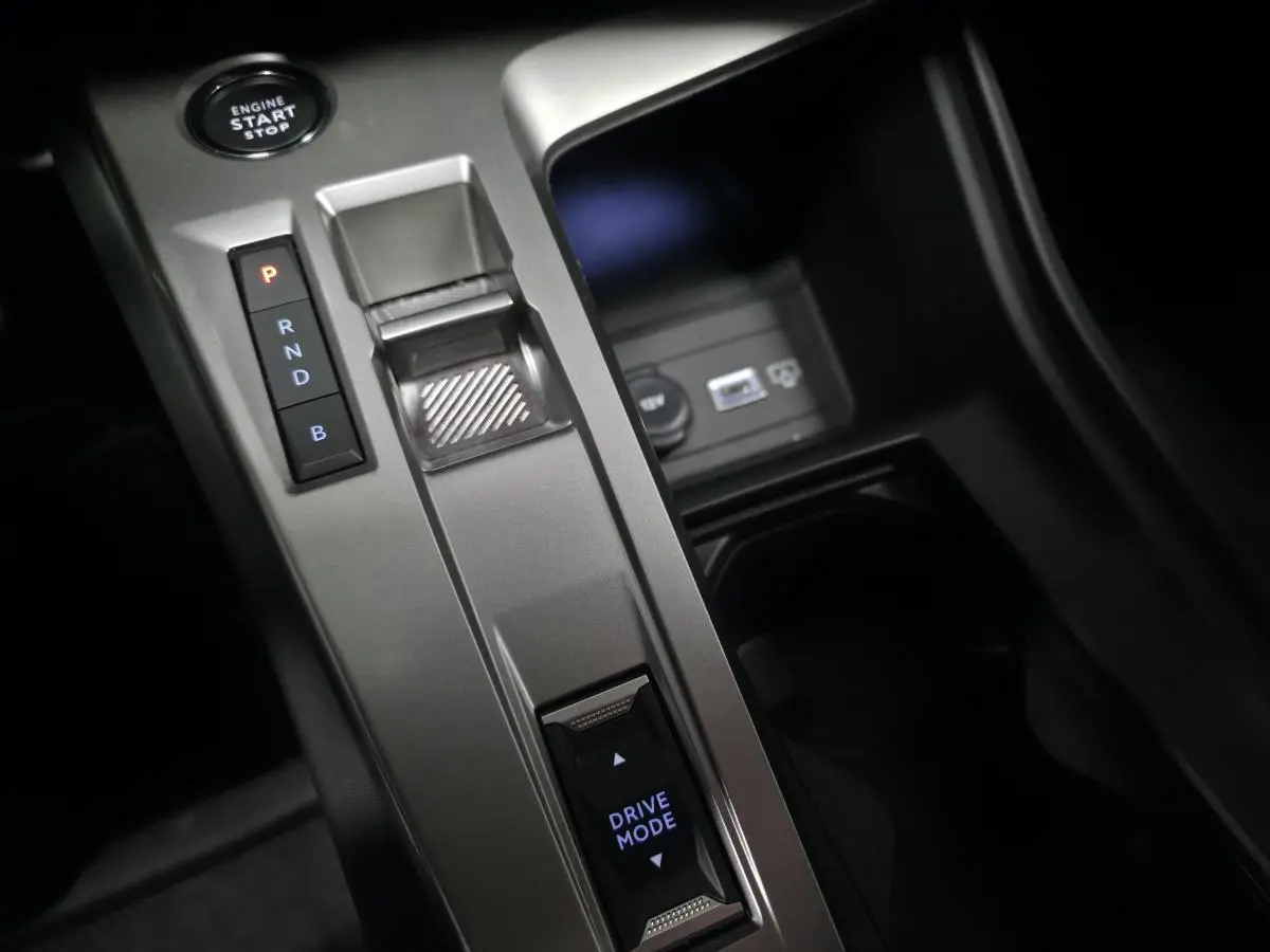 Gros plan sur la console centrale grise avec sélecteur de boîte auto et bouton Drive Mode de la Peugeot 408 noire.