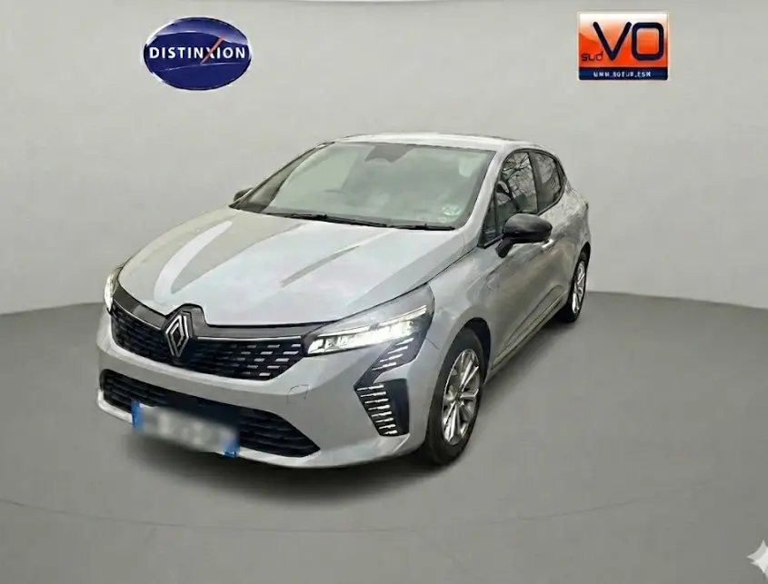 Renault Clio gris en vue 3/4 avant droit, avec calandre noire et feux LED distinctifs allumés.