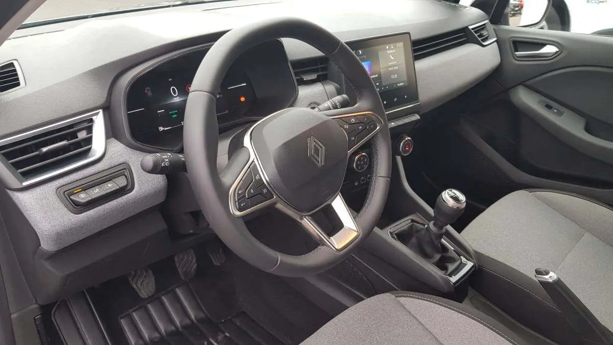 Vue intérieure côté conducteur de la Renault Clio V dCi 100 Evolution 2025, volant multifonction et boîte manuelle visibles.