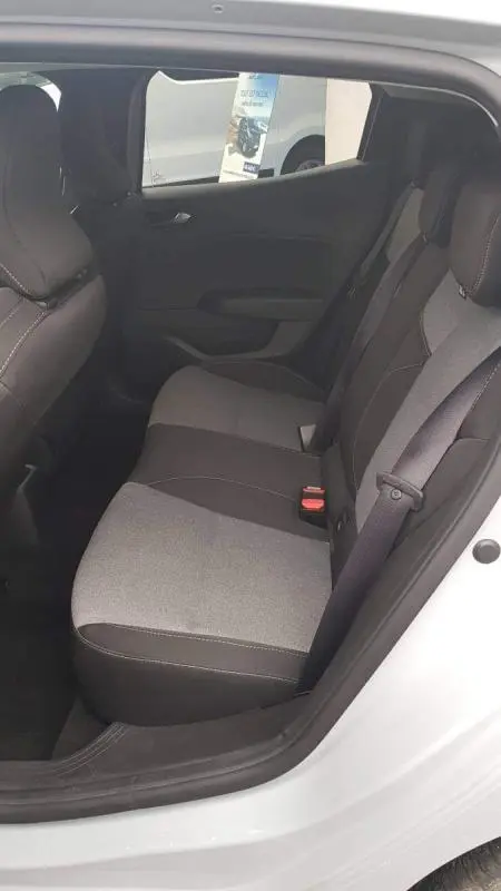 Vue intérieure arrière droite de la Renault Clio gris 2025, montrant les sièges arrière en tissu bicolore et la ceinture centrale 3 points.