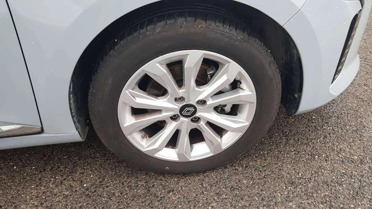 Gros plan sur la roue avant droite d’une Renault Clio gris clair 2025 avec jante alliage moderne.