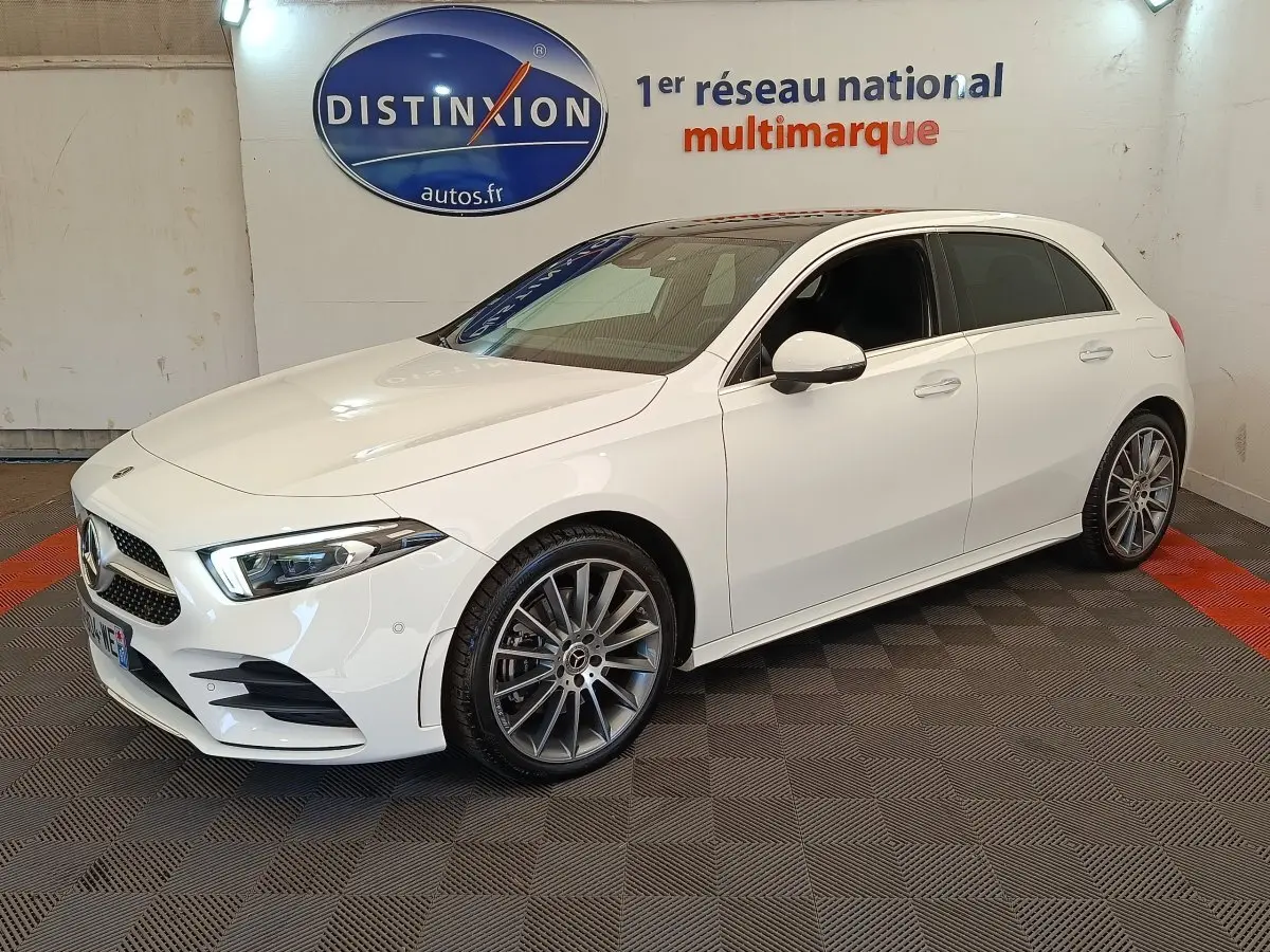 Mercedes Classe A 250 e AMG Line blanc vue 3/4 avant droit, jantes alliage et phares LED ellipsoïdaux visibles.