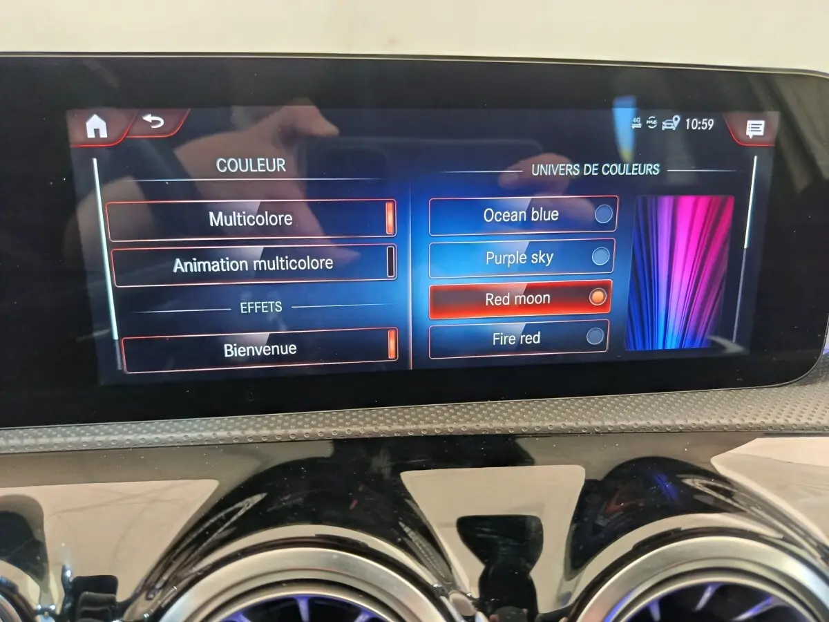 Écran tactile central de la Mercedes Classe A 250 e AMG Line 2021 affichant les options de couleurs d'ambiance intérieure.
