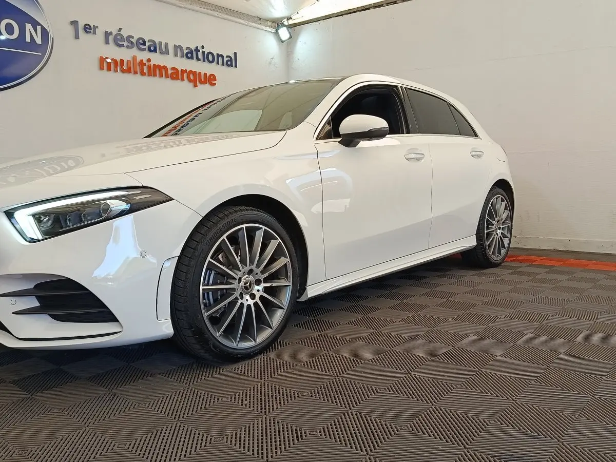 Mercedes Classe A 250 e AMG Line blanche vue de côté gauche avant, avec jantes alliage distinctives.
