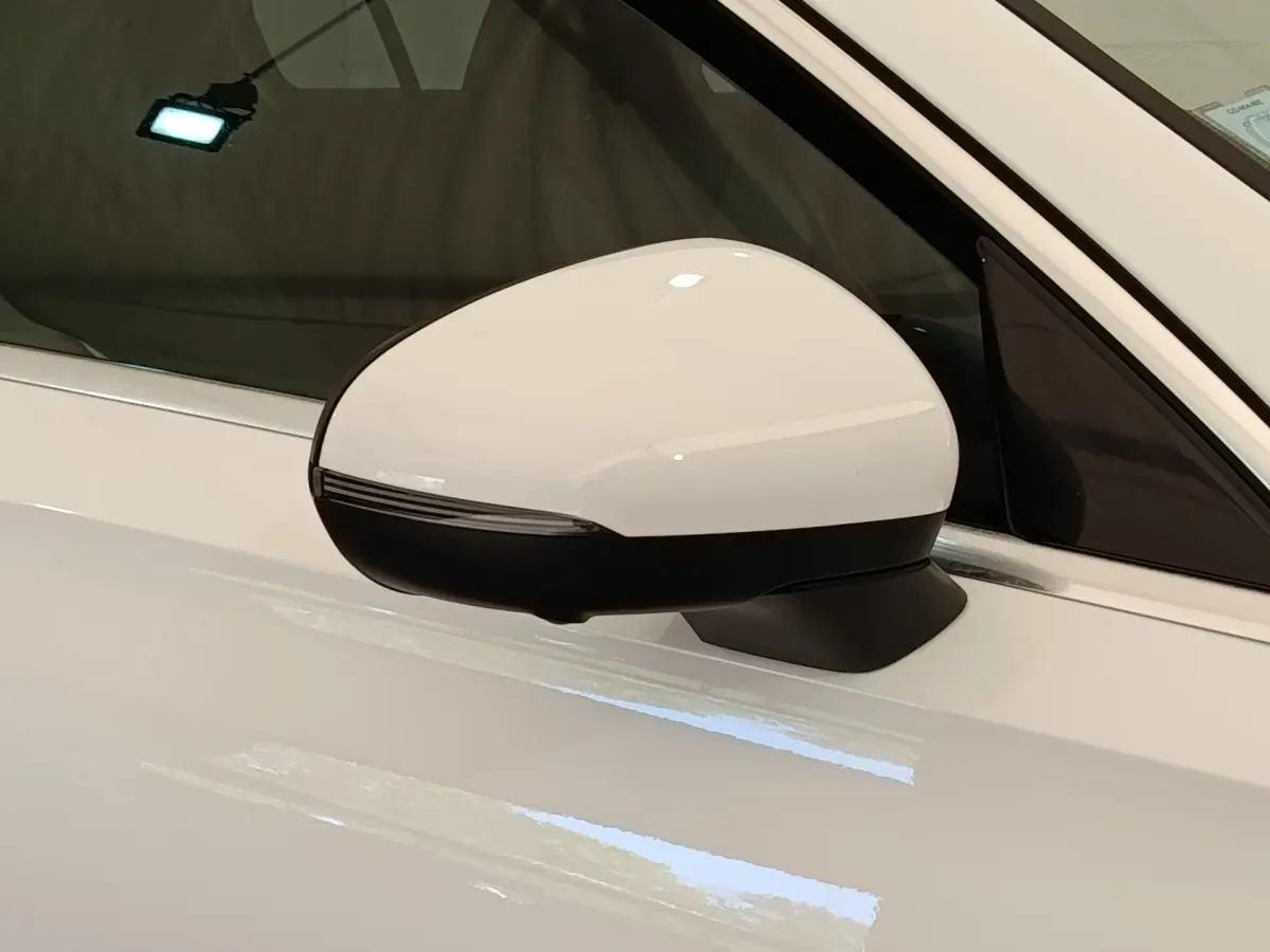 Gros plan sur le rétroviseur droit blanc et noir d'une Mercedes Classe A A 250 e AMG Line 2021 hybride rechargeable.