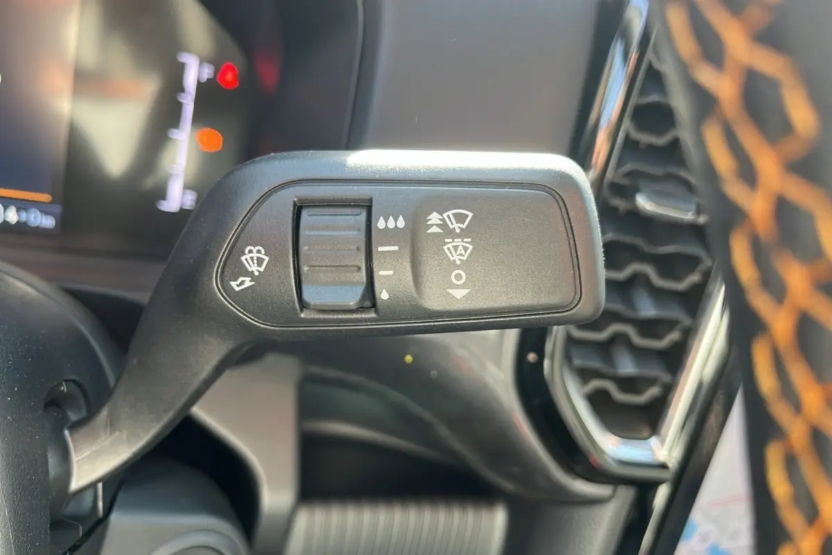 Gros plan sur la commande d’essuie-glace à gauche du volant du Ford Ranger gris carbone, avec tableau de bord flou en arrière-plan.