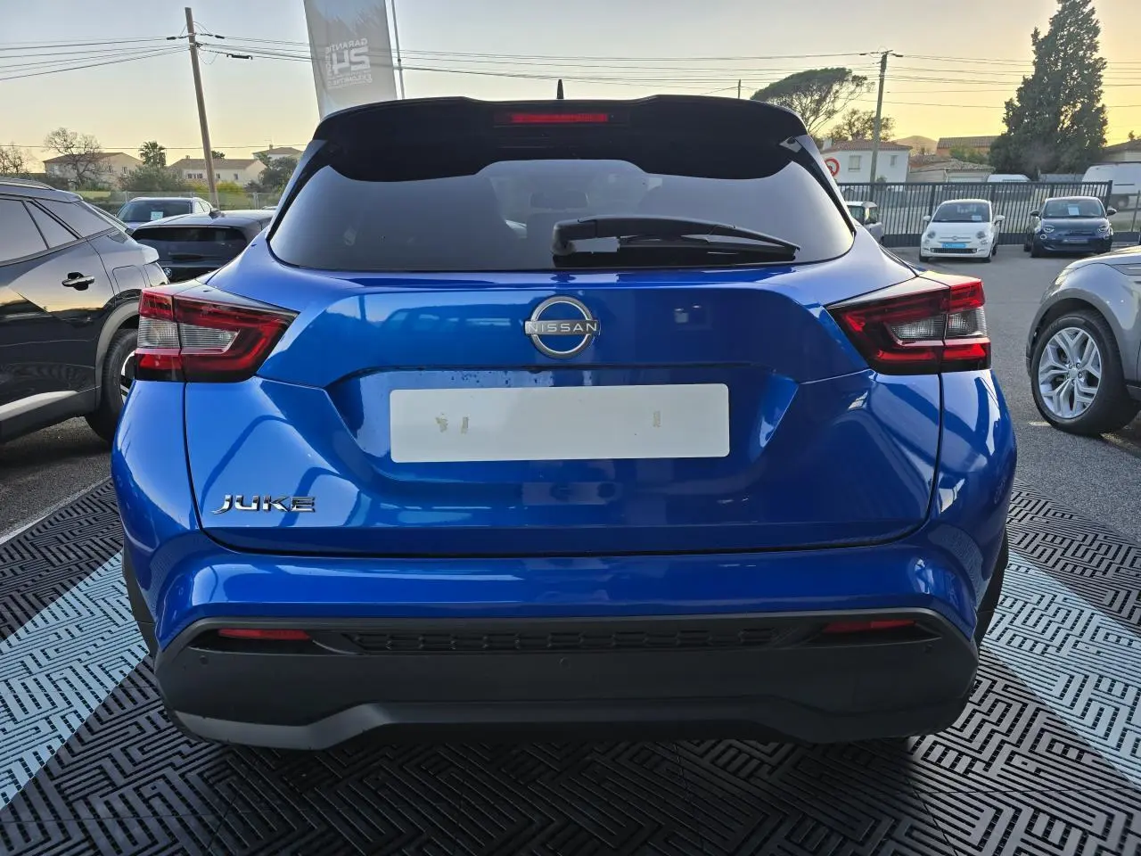 Vue arrière d'un Nissan Juke II bleu magnetic avec feux LED et logo Nissan bien visibles.