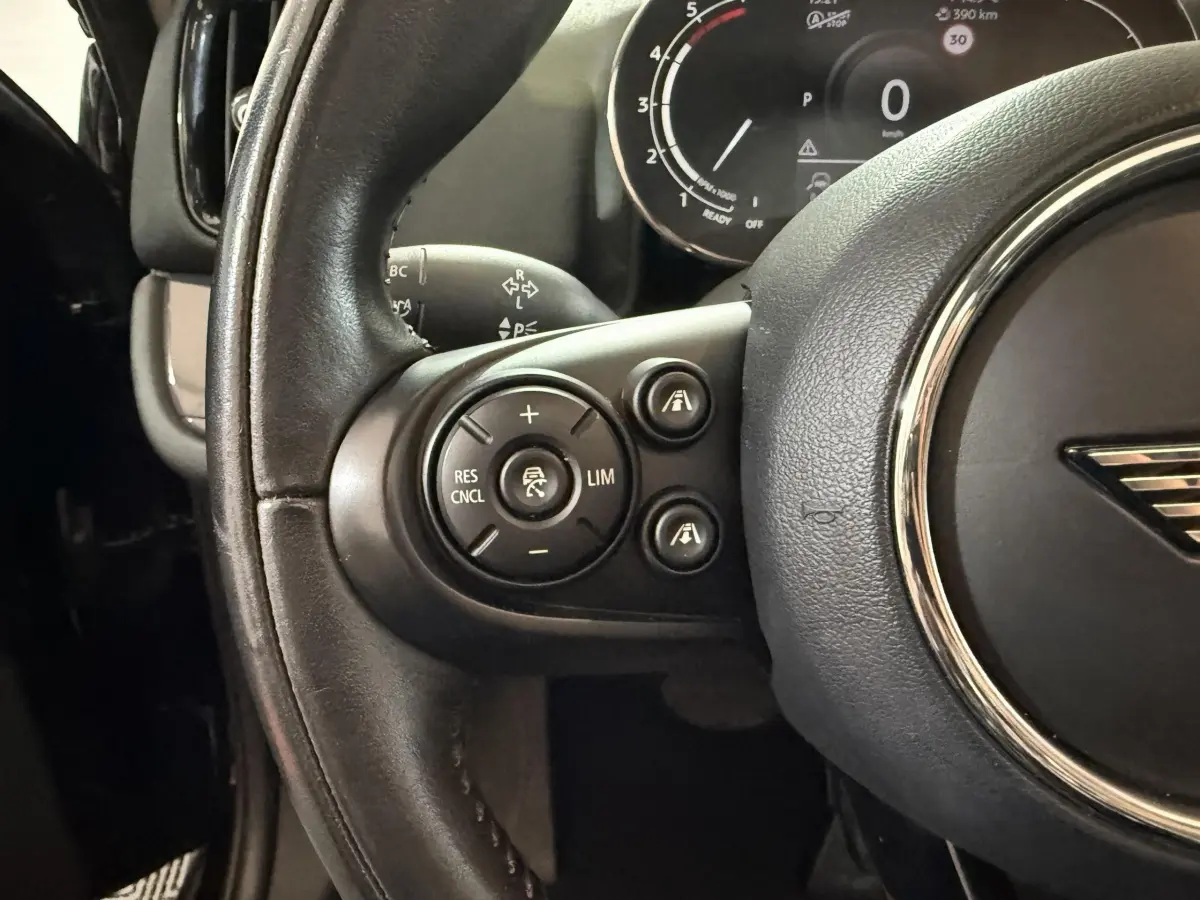 Gros plan sur le volant cuir noir de la MINI Countryman 2020 avec commandes de régulateur de vitesse visibles côté gauche.