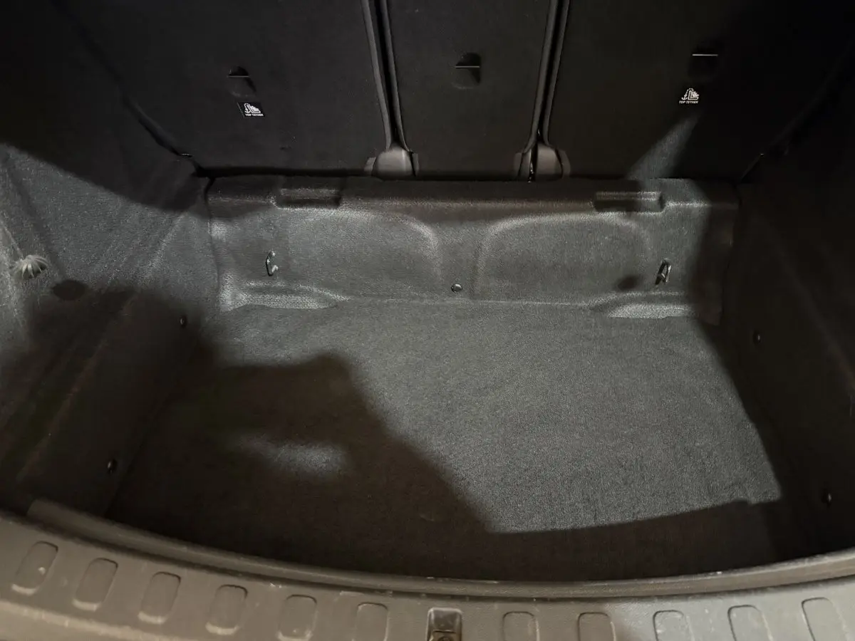 Vue intérieure du coffre noir du MINI COUNTRYMAN Cooper D Business Design 2020, montrant l'espace de chargement vide et les dossiers arrière rabattus.